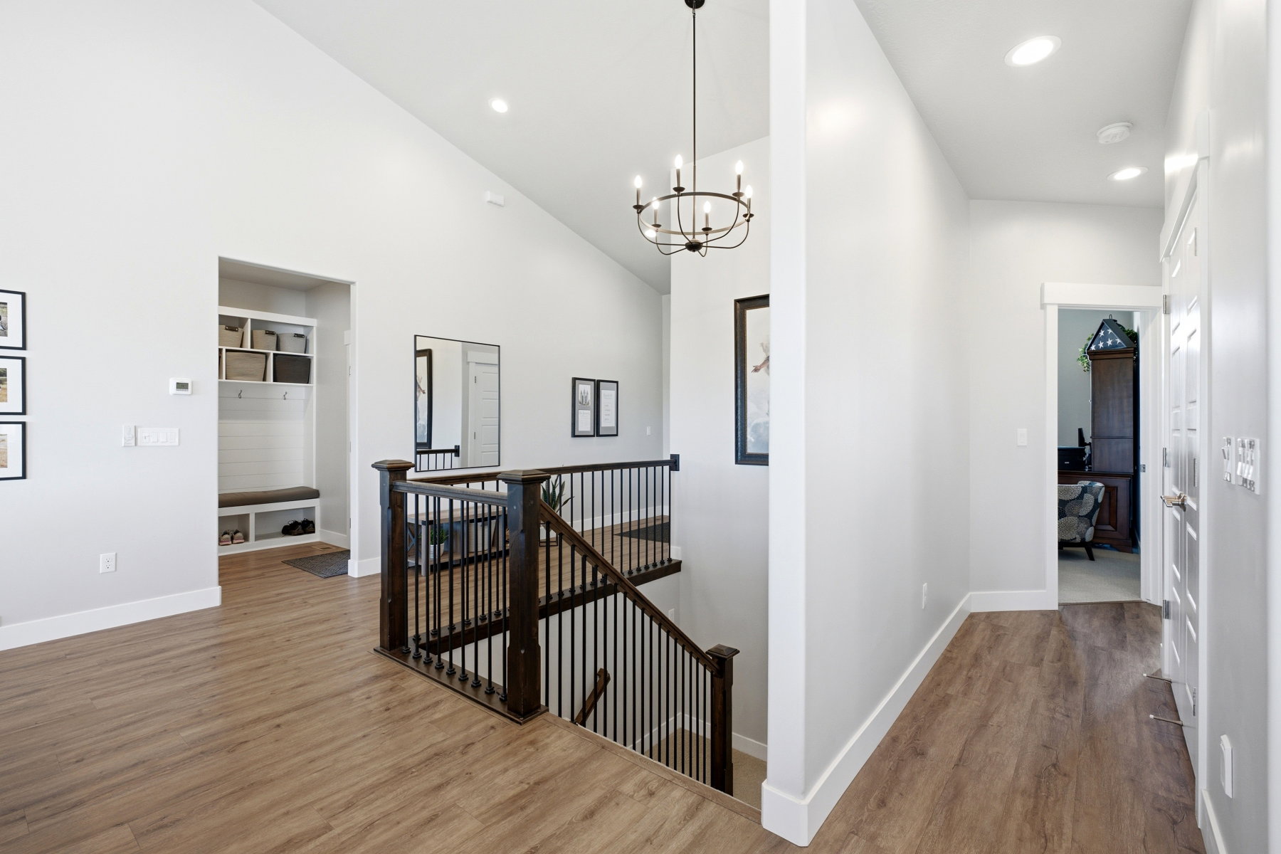 Open concept hallway featuring wood-finish flooring and a built-in mudroom bench with shelving