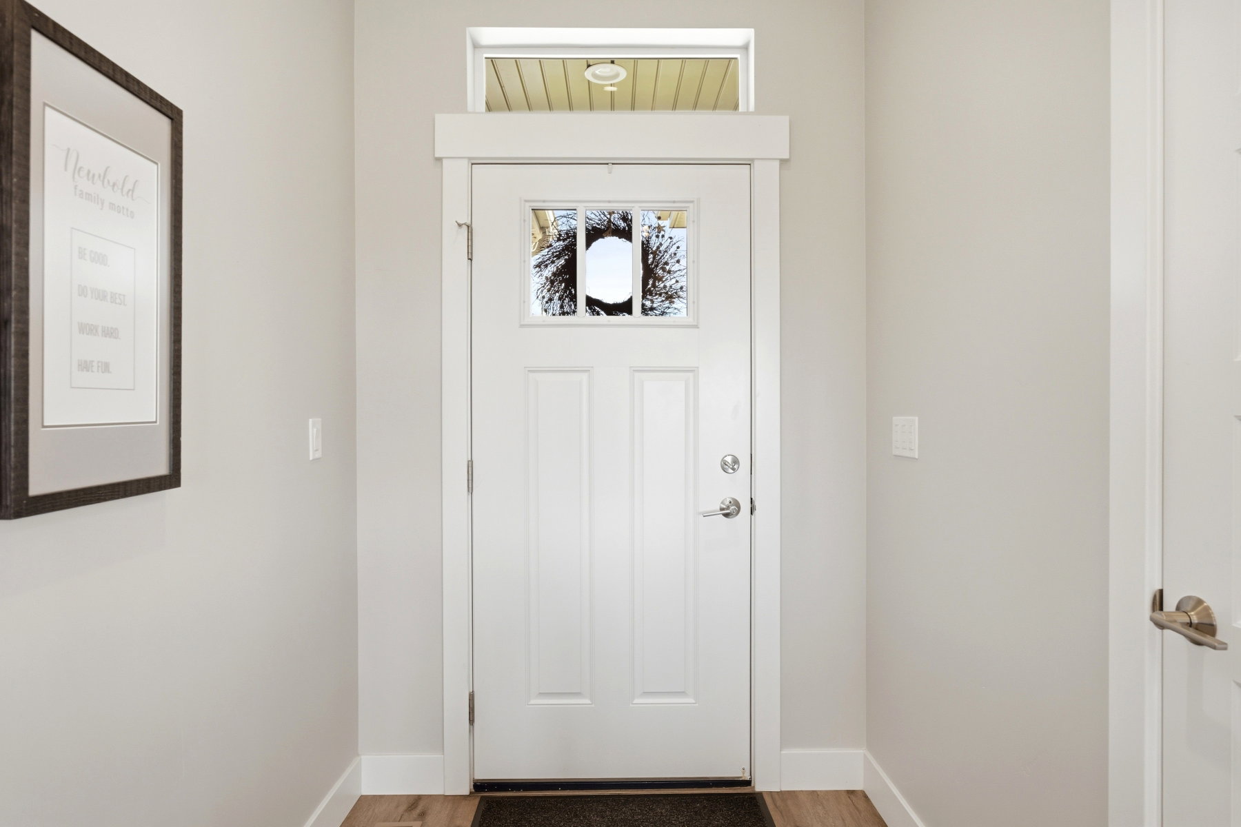 White paneled entry door with frosted glass insert and transom window