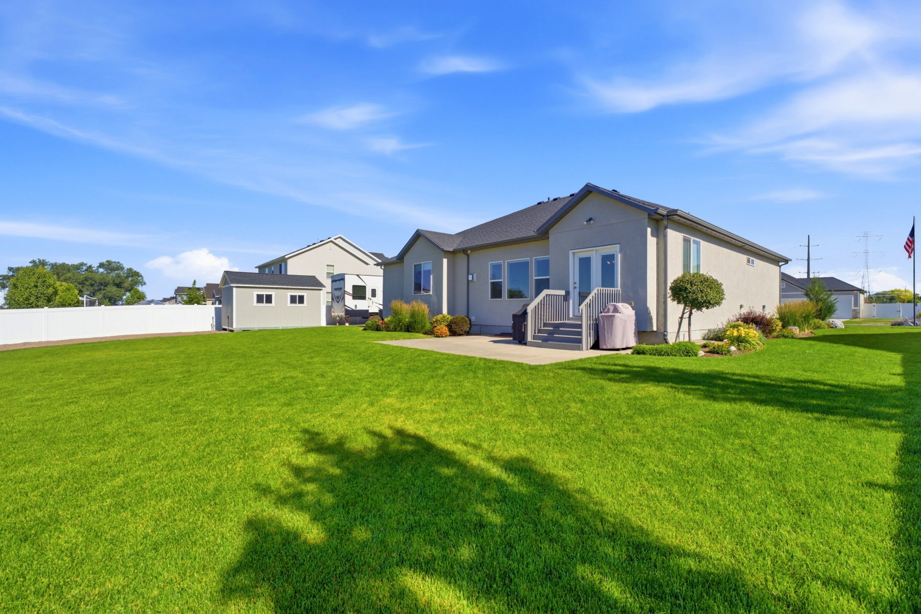 Expansive backyard featuring a manicured lawn, a detached storage shed, and a privacy fence