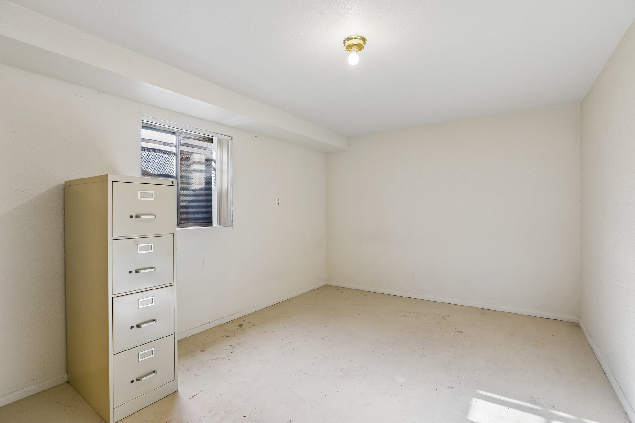 Basement room featuring a single window and an overhead light fixture