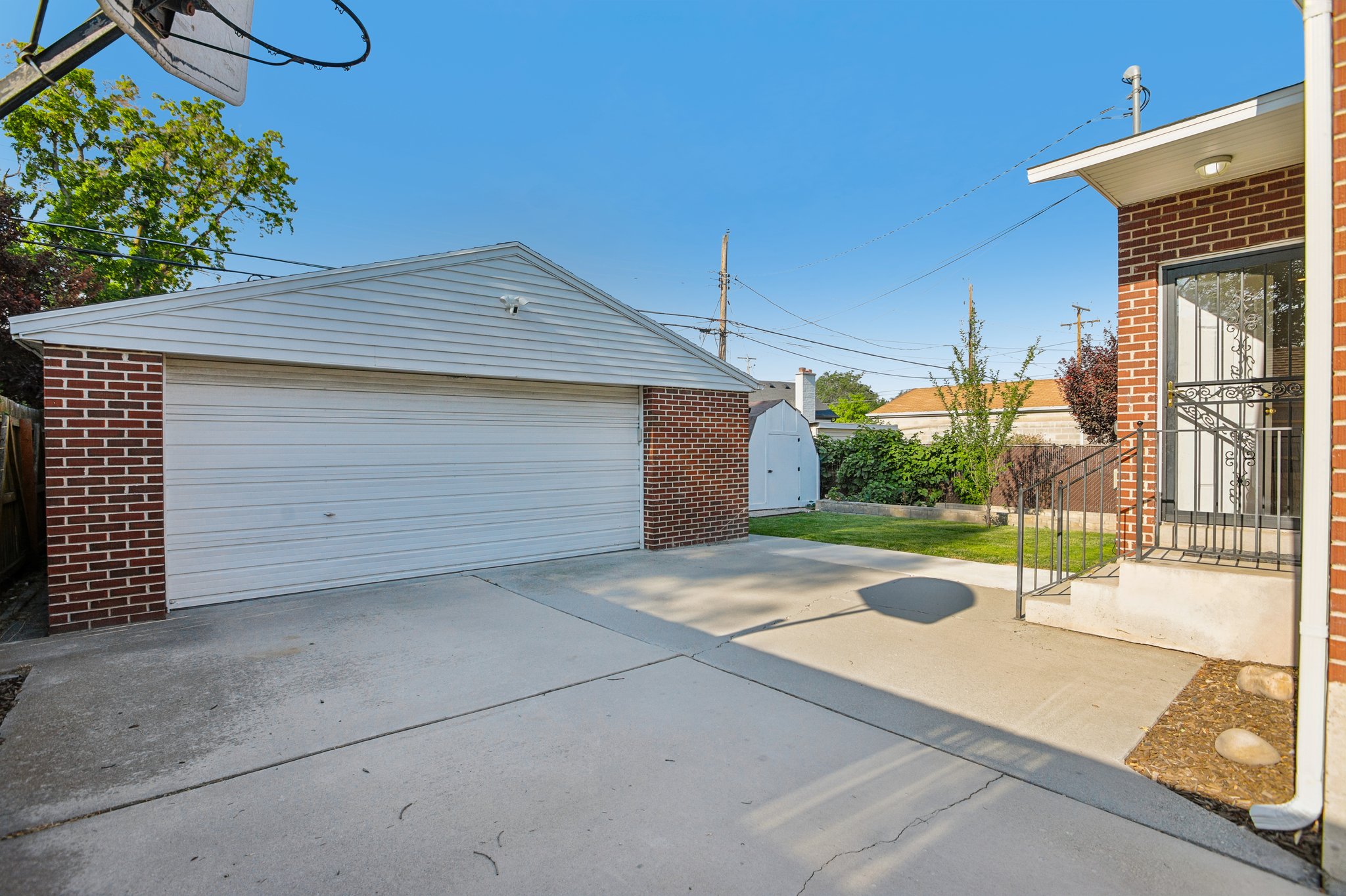 Detached two-car garage with brick base and horizontal siding