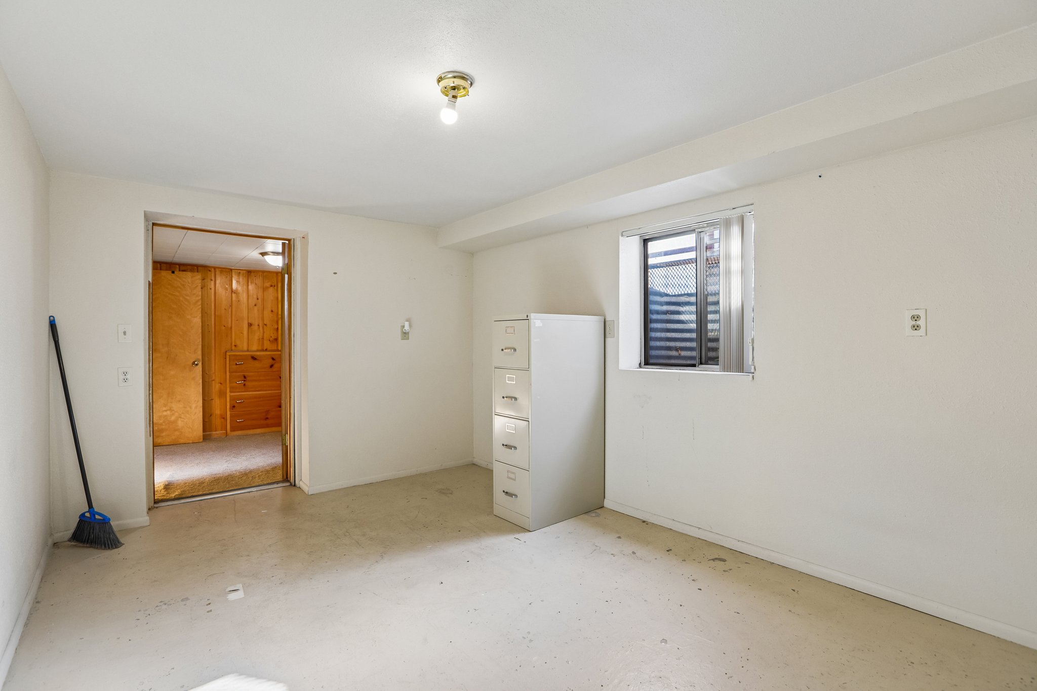 Versatile room featuring light-colored flooring and a window with horizontal blinds
