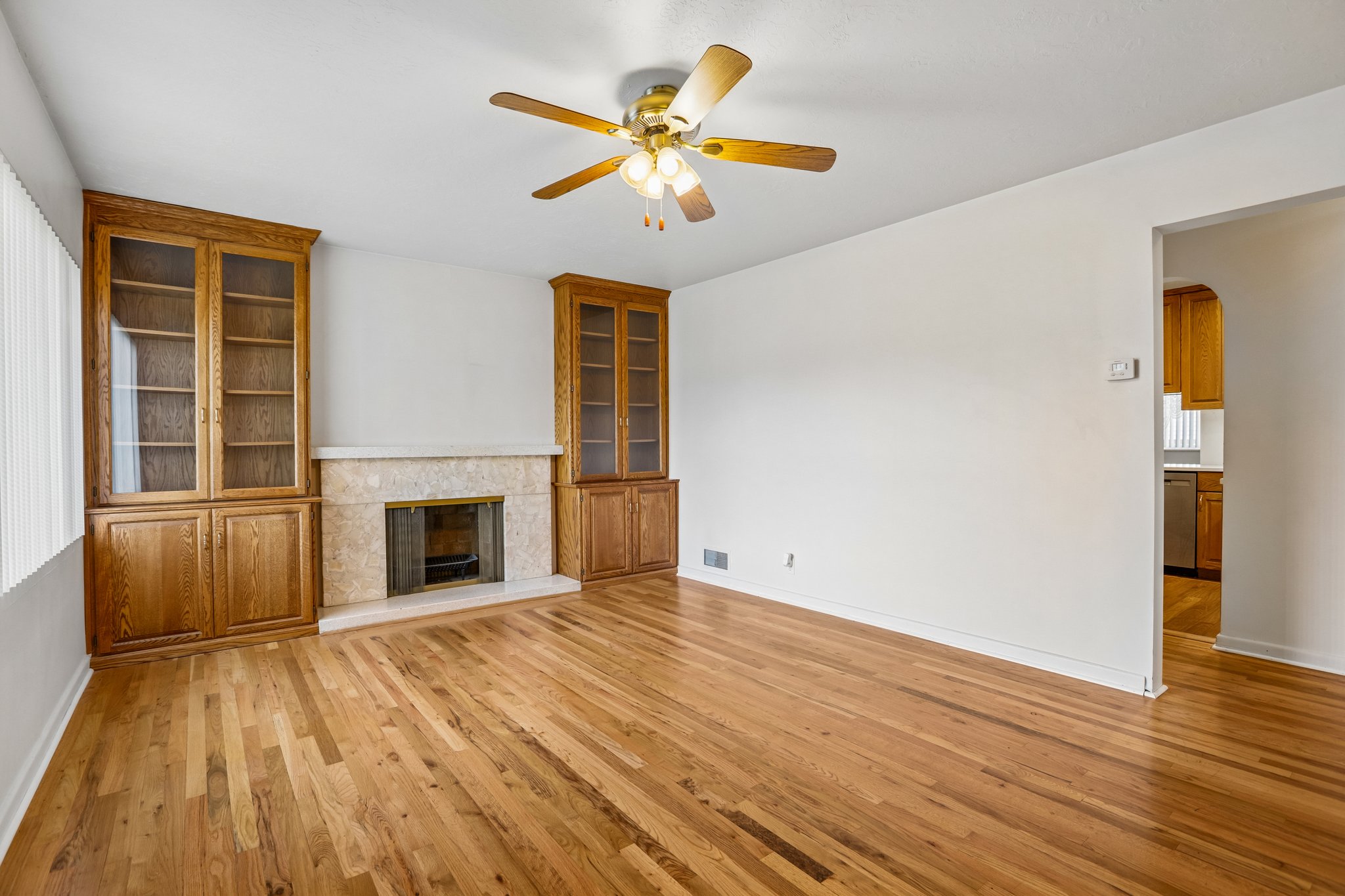 Living area featuring wood-finish flooring and a ceiling fan