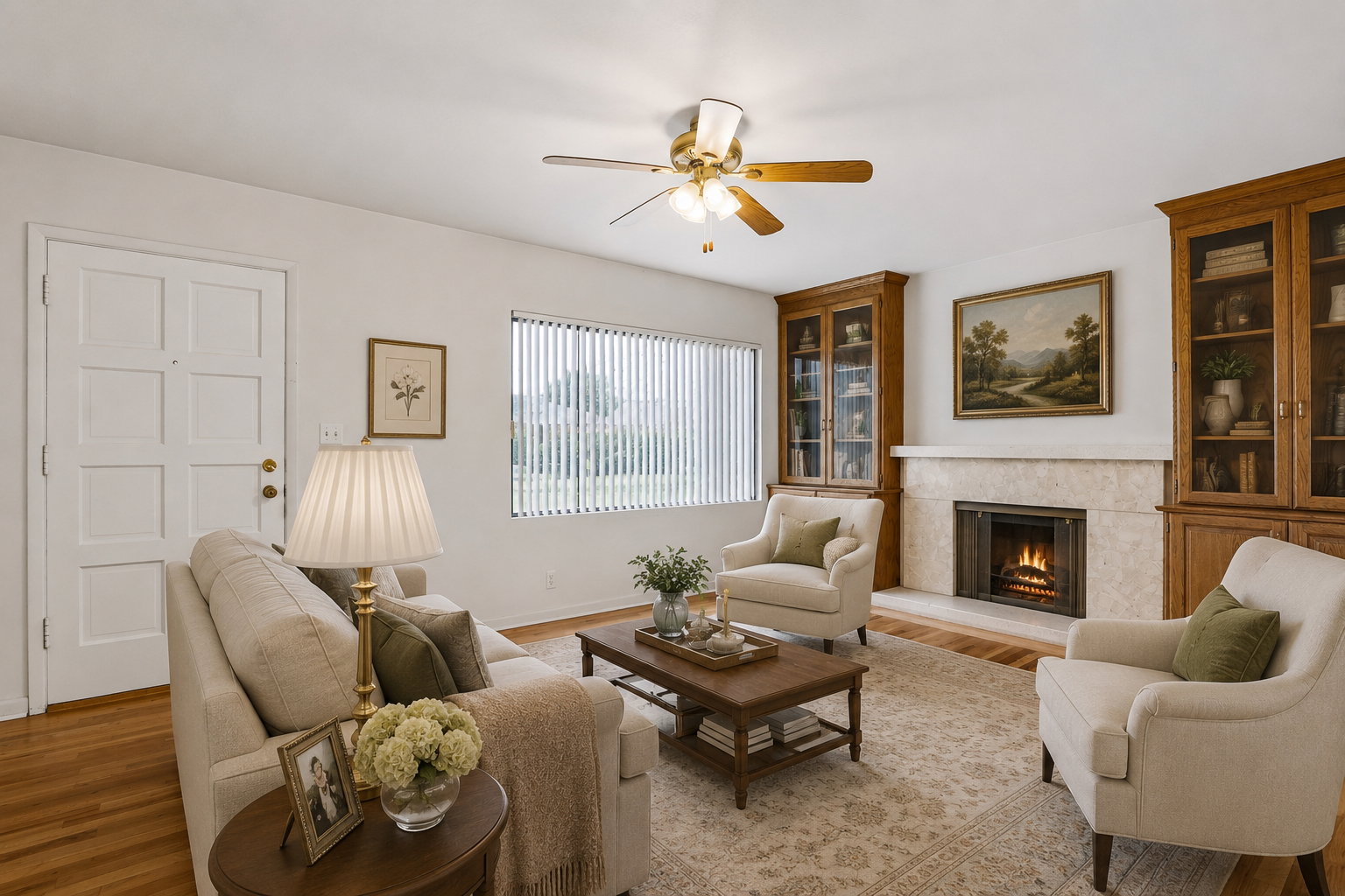 Living room featuring a built-in fireplace with a stone surround, wood-finish flooring, a ceiling fan, and two built-in wood-finish display cabinets