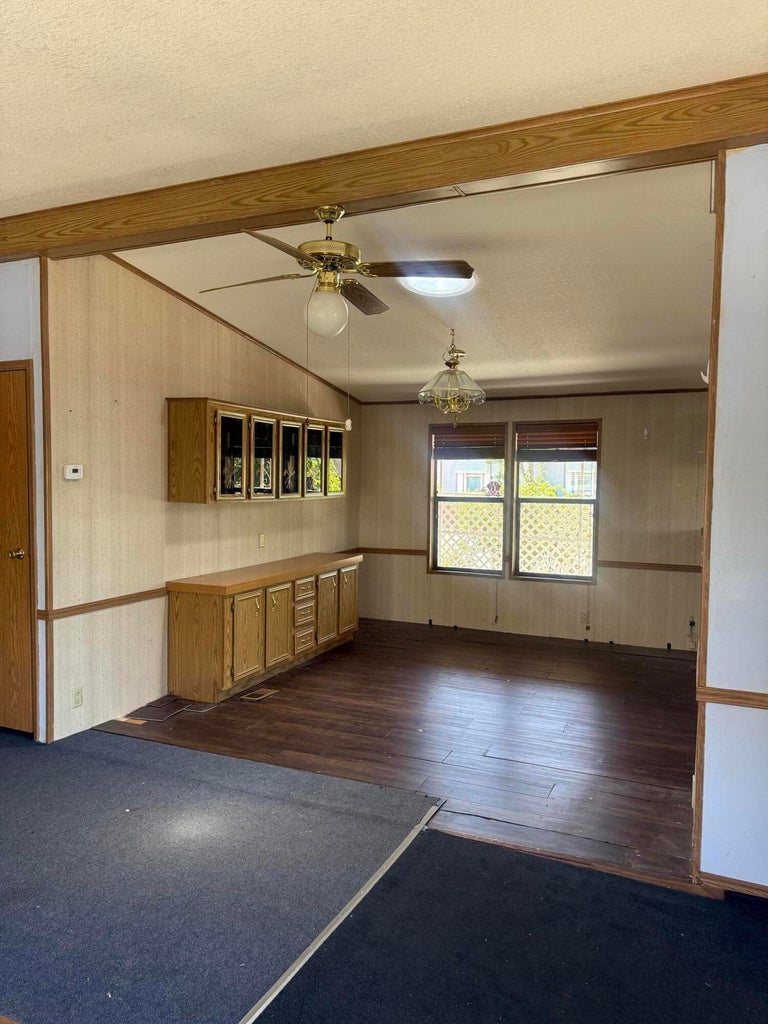 Spacious room featuring wood-finish flooring, a built-in cabinetry unit, and large windows