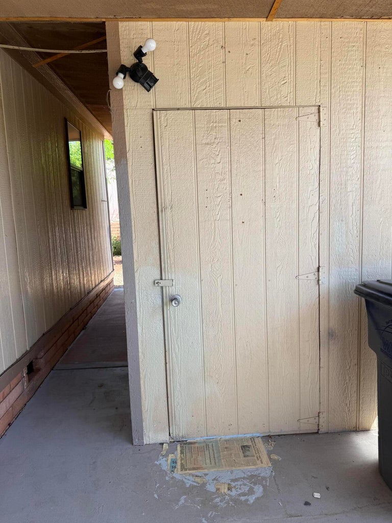 Exterior utility door featuring a latch and knob hardware