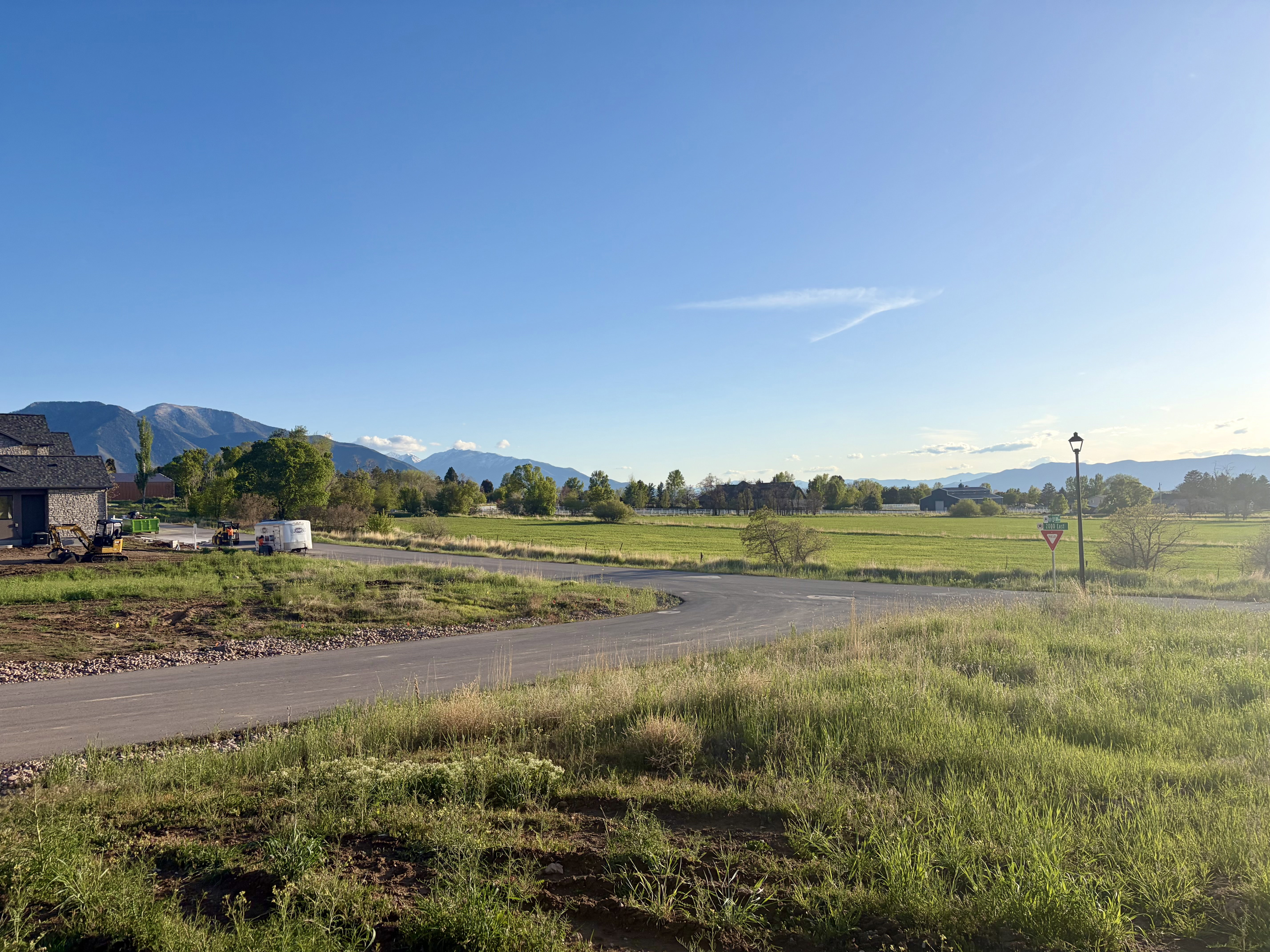 Expansive green fields with distant mountains under a clear sky