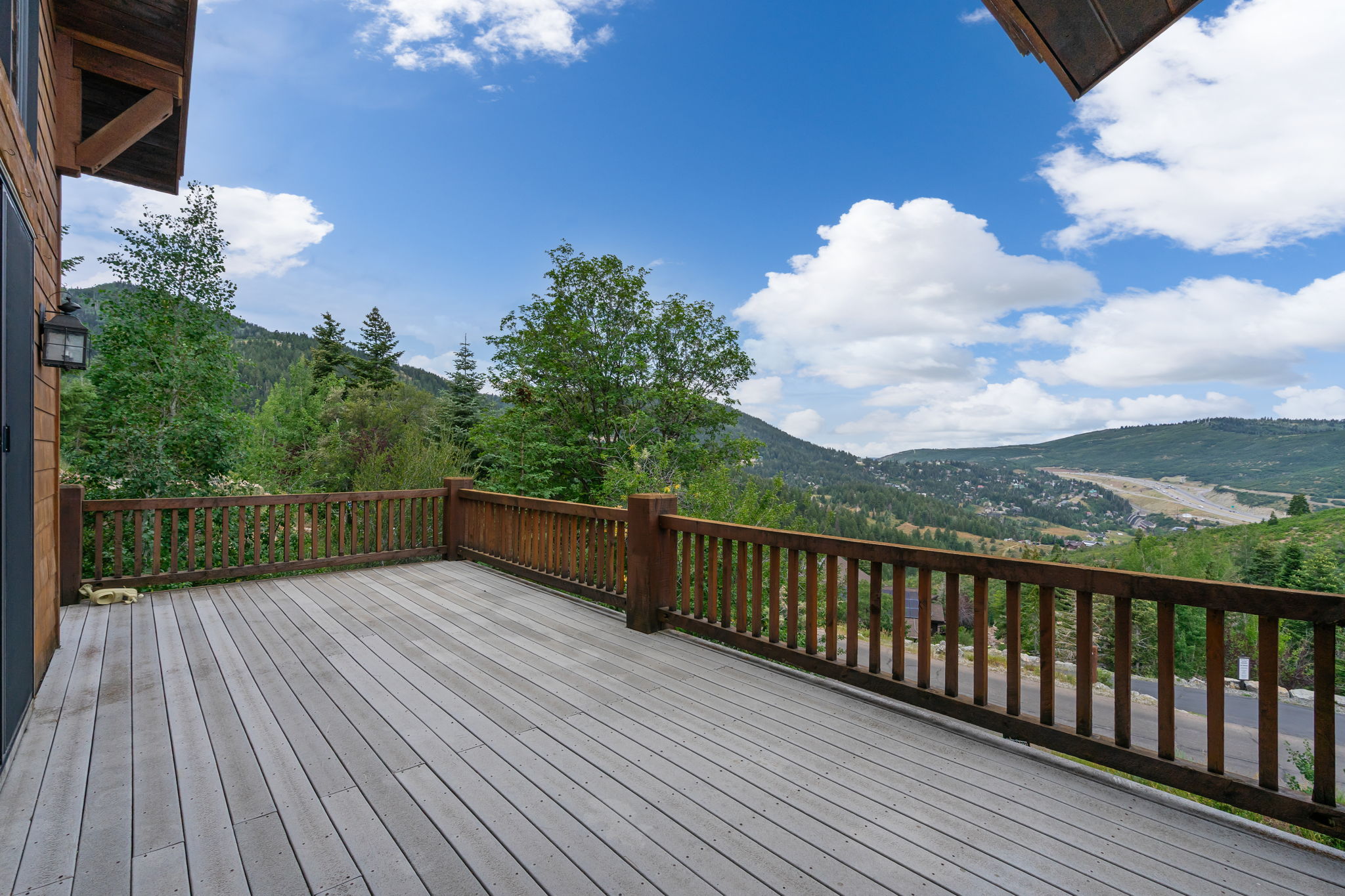 Spacious outdoor deck with wood-finish flooring and a wood railing