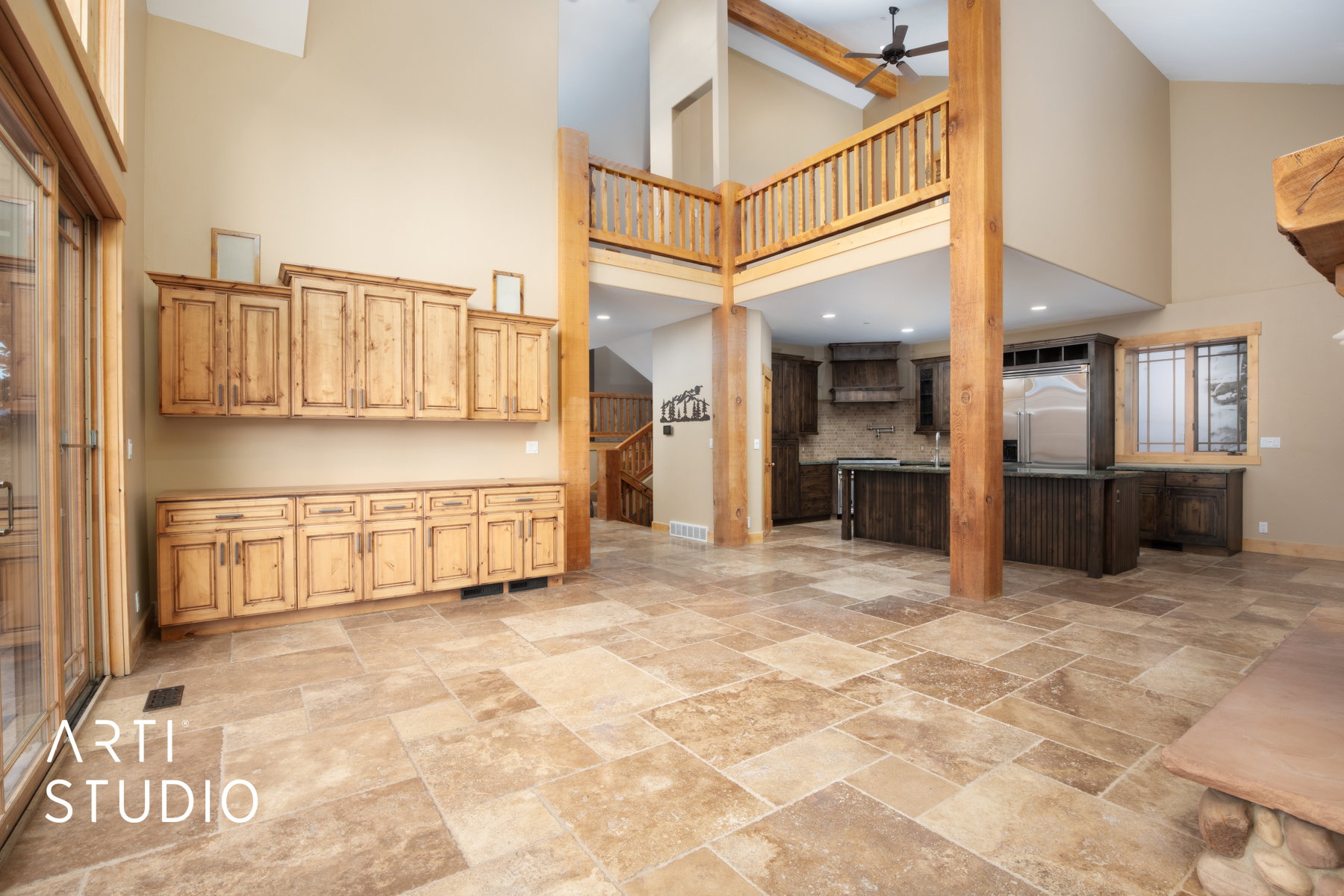 Spacious open-concept interior featuring light-toned tile flooring throughout the main level