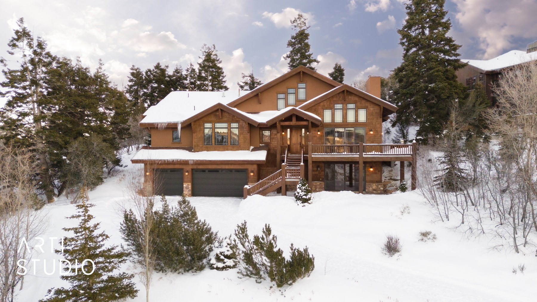 Multi-level residence featuring a warm wood exterior, multiple large windows, and a spacious outdoor deck