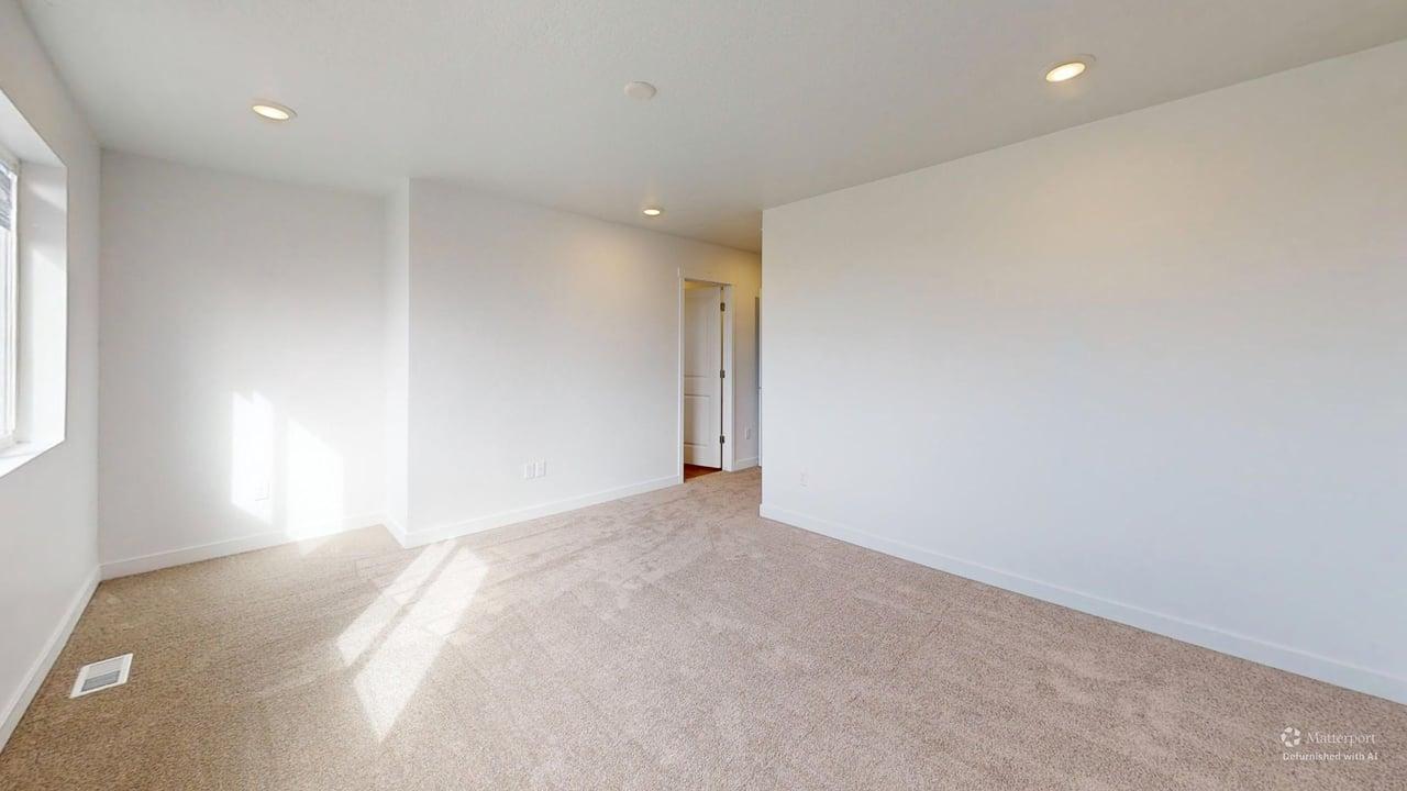 Spacious room featuring neutral carpeting, a large window, recessed lighting, and white walls