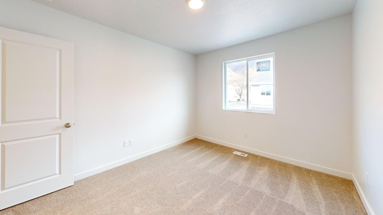 Room featuring light-colored carpet flooring, white walls, and a single window with a white frame