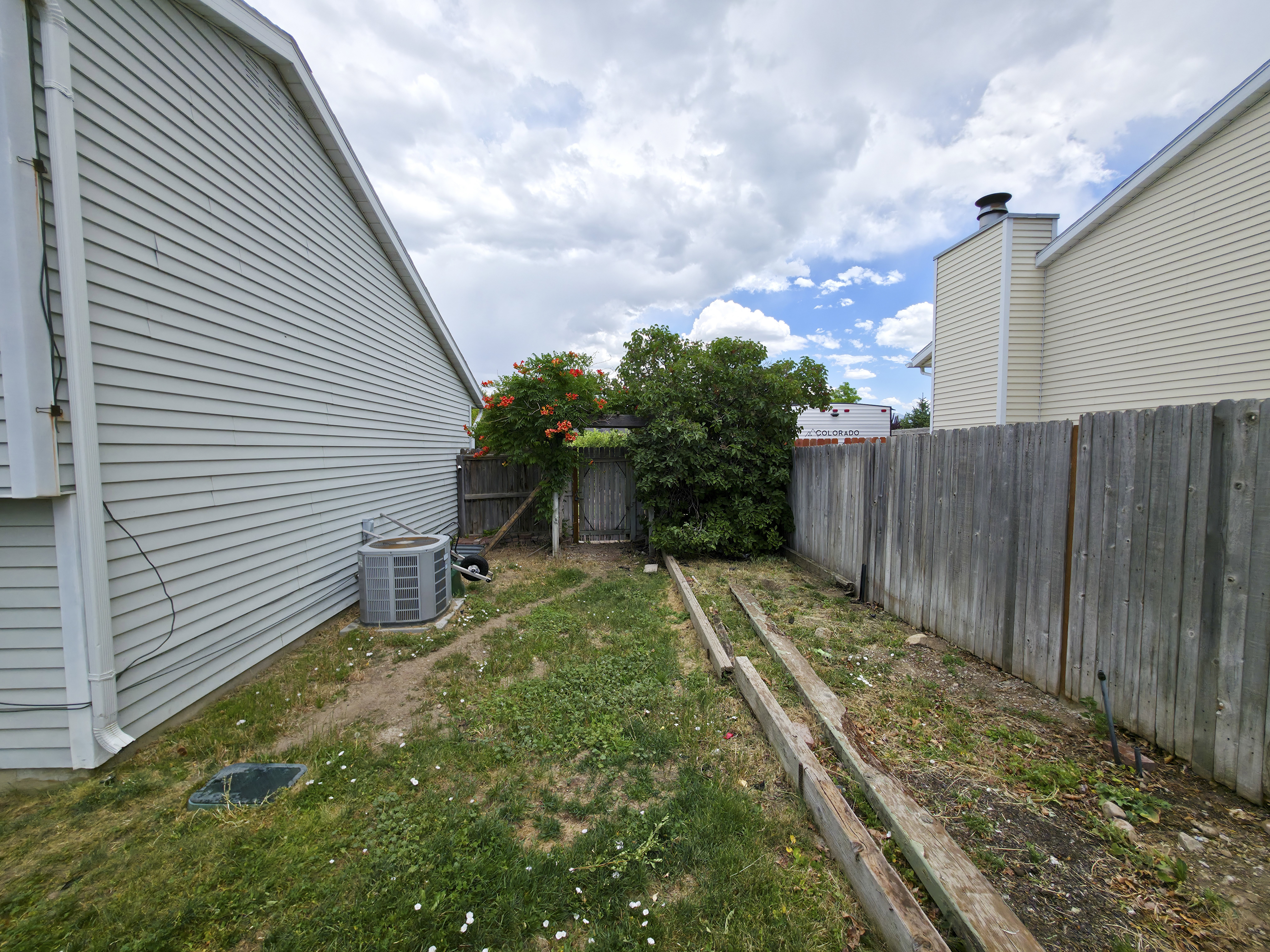 Back yard, south side, AC on left, vegetable garden on right.