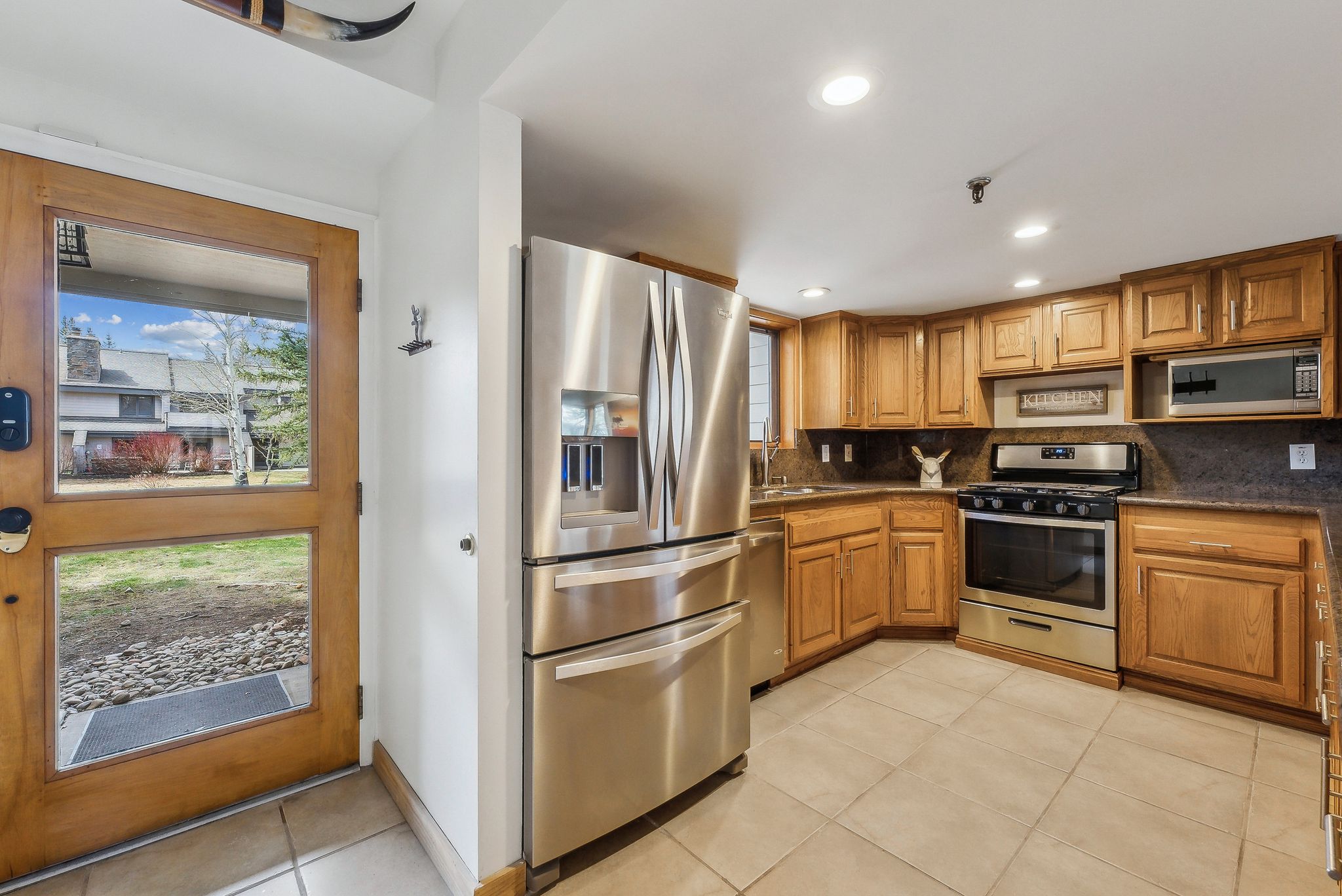 Kitchen featuring wood cabinetry, stainless steel appliances, and tile flooring