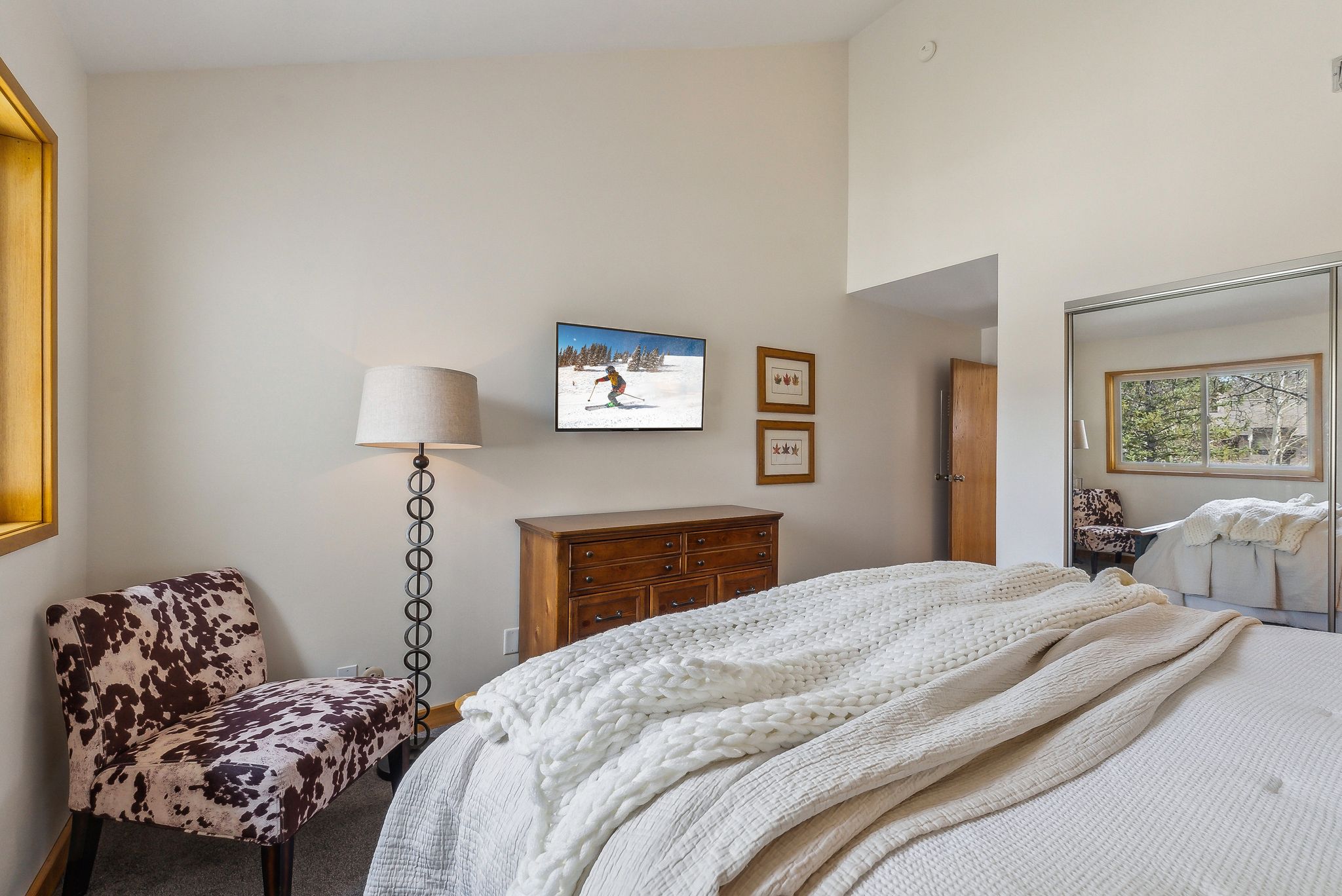 Bedroom featuring a vaulted ceiling and an integrated sliding mirrored closet door