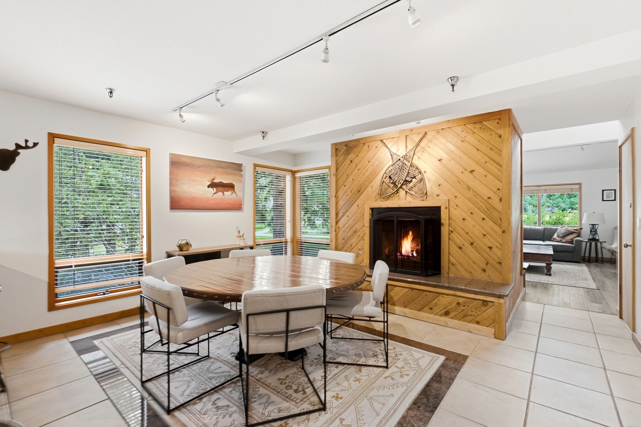 Tile flooring extending to a wood-finish accent wall with an integrated fireplace and hearth
