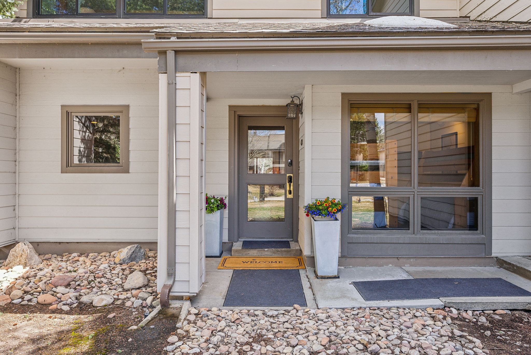 Entryway featuring a panel door with glass insert, a large picture window, and a square window with dark trim