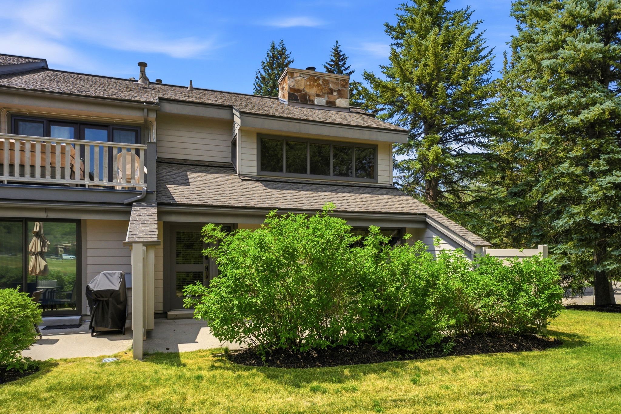 Multi-level exterior with light-colored siding and a shingle roof