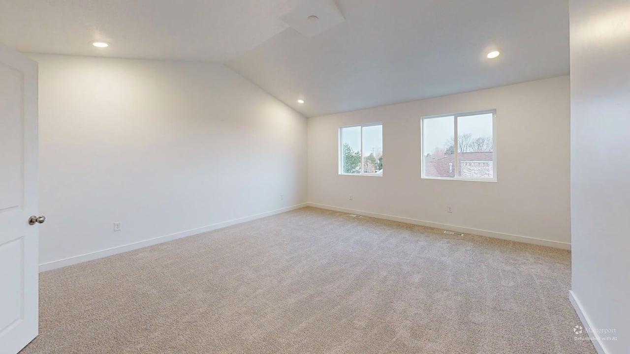 Spacious room featuring neutral carpet flooring, recessed lighting, and two windows providing exterior light