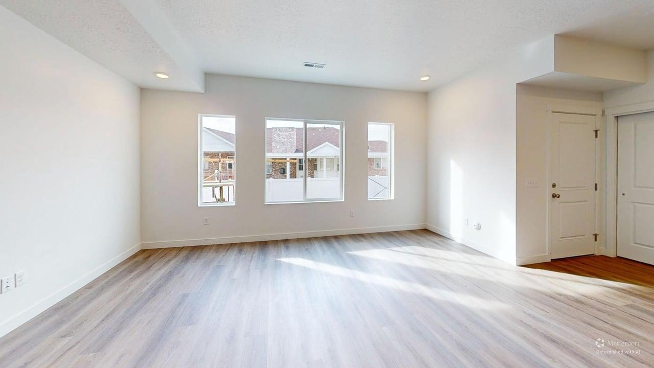 Spacious room with light wood-finish flooring, recessed lighting, and multiple windows
