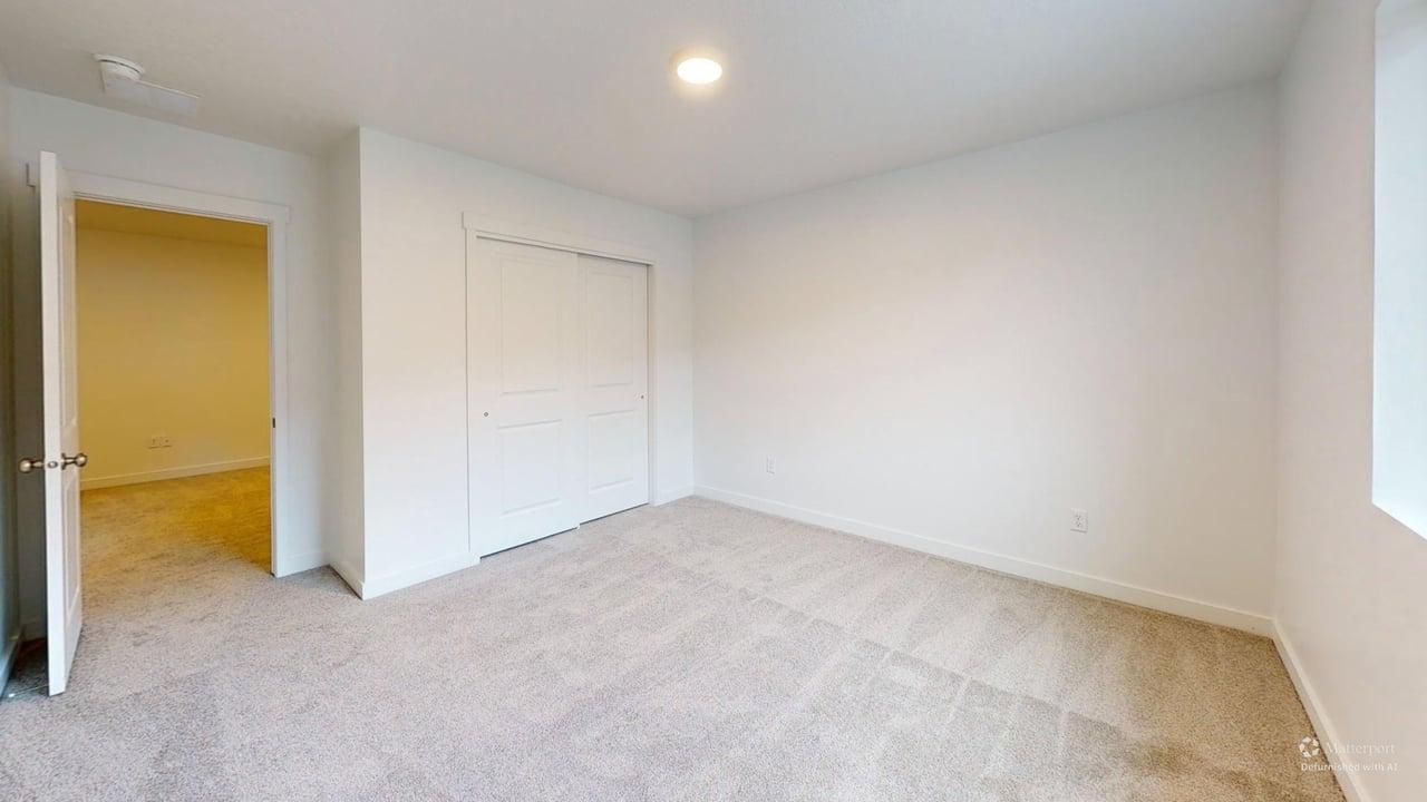 Carpeted room featuring a ceiling-mounted light fixture, white walls, and white trim