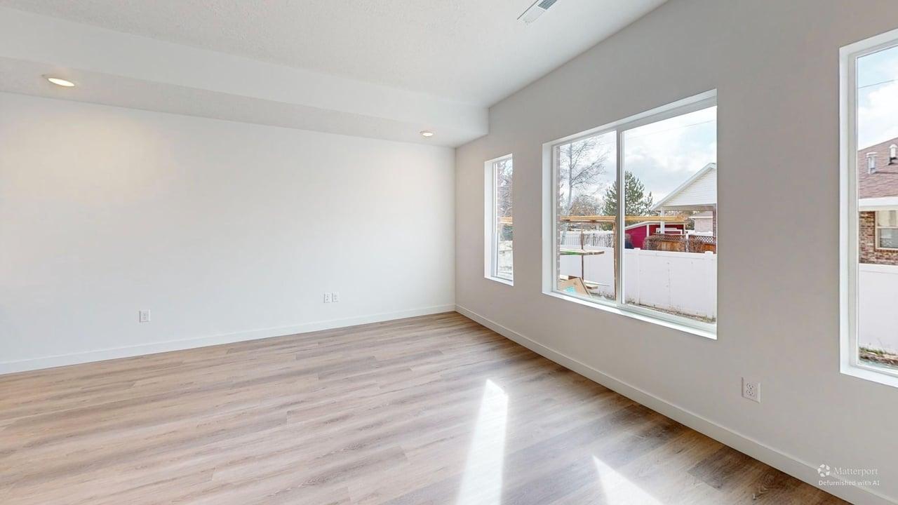 Spacious room featuring wood-finish flooring, recessed lighting, and multiple windows