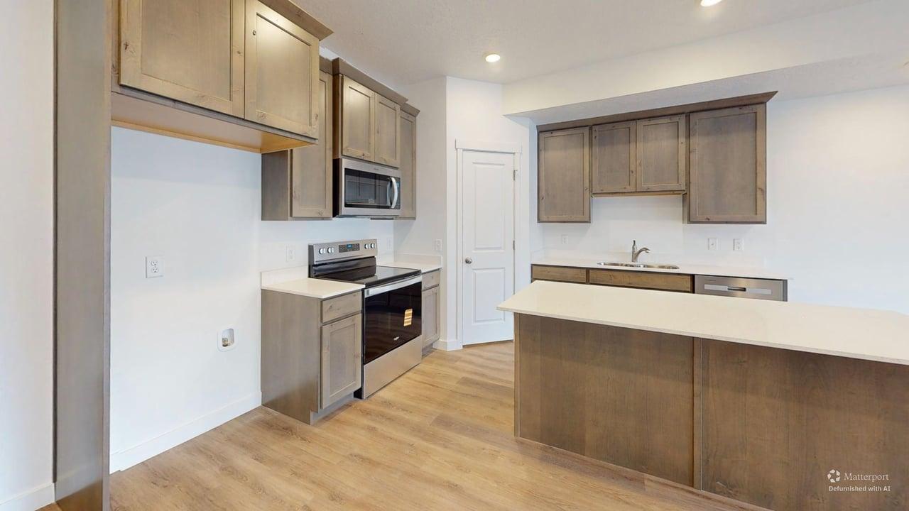 Kitchen featuring an eat-at island, stainless steel appliances, wood-finish flooring, recessed lighting, and a pantry door