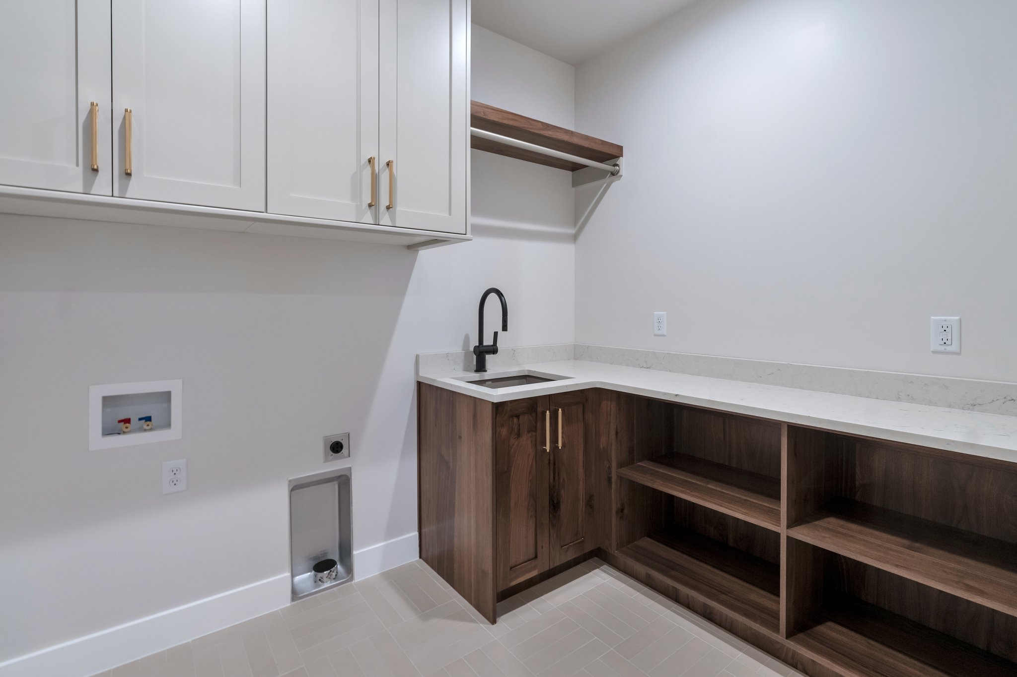 Laundry room featuring extensive cabinetry, a built-in sink with a matte black faucet, and ample counter space