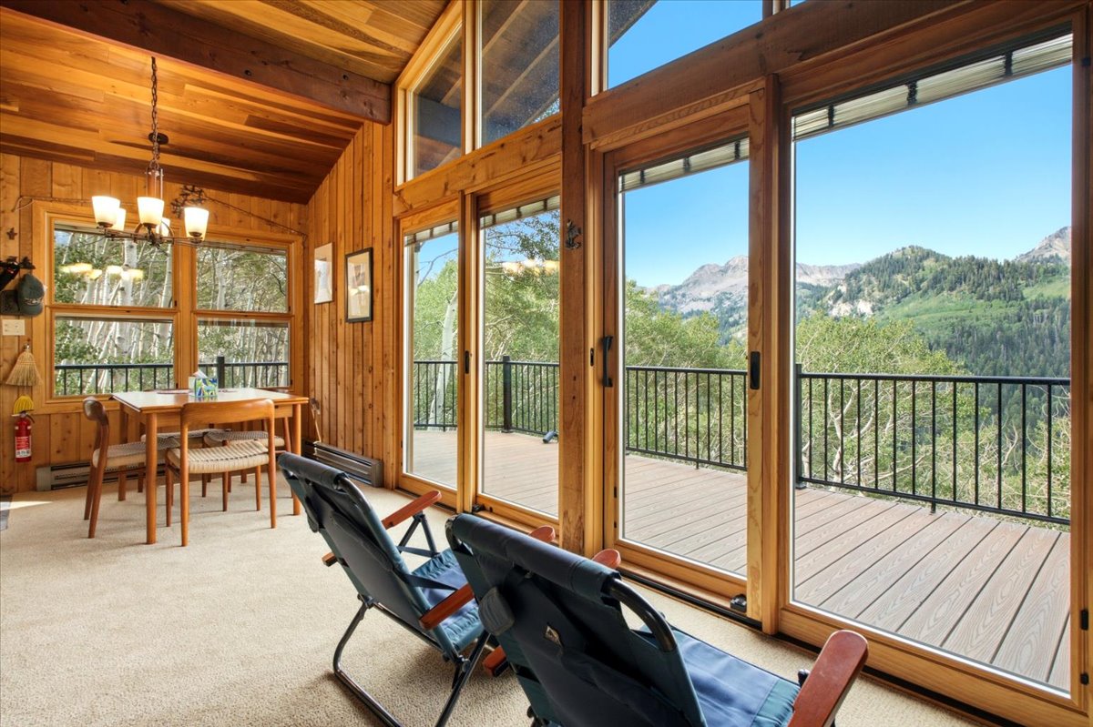 Expansive deck with mountain scenery, accessed by multiple glass sliding doors