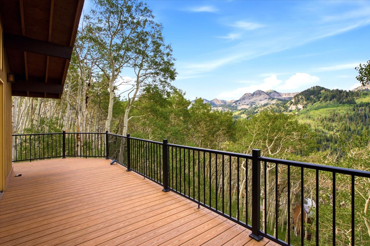 Expansive outdoor deck featuring wood-finish flooring and black metal railings