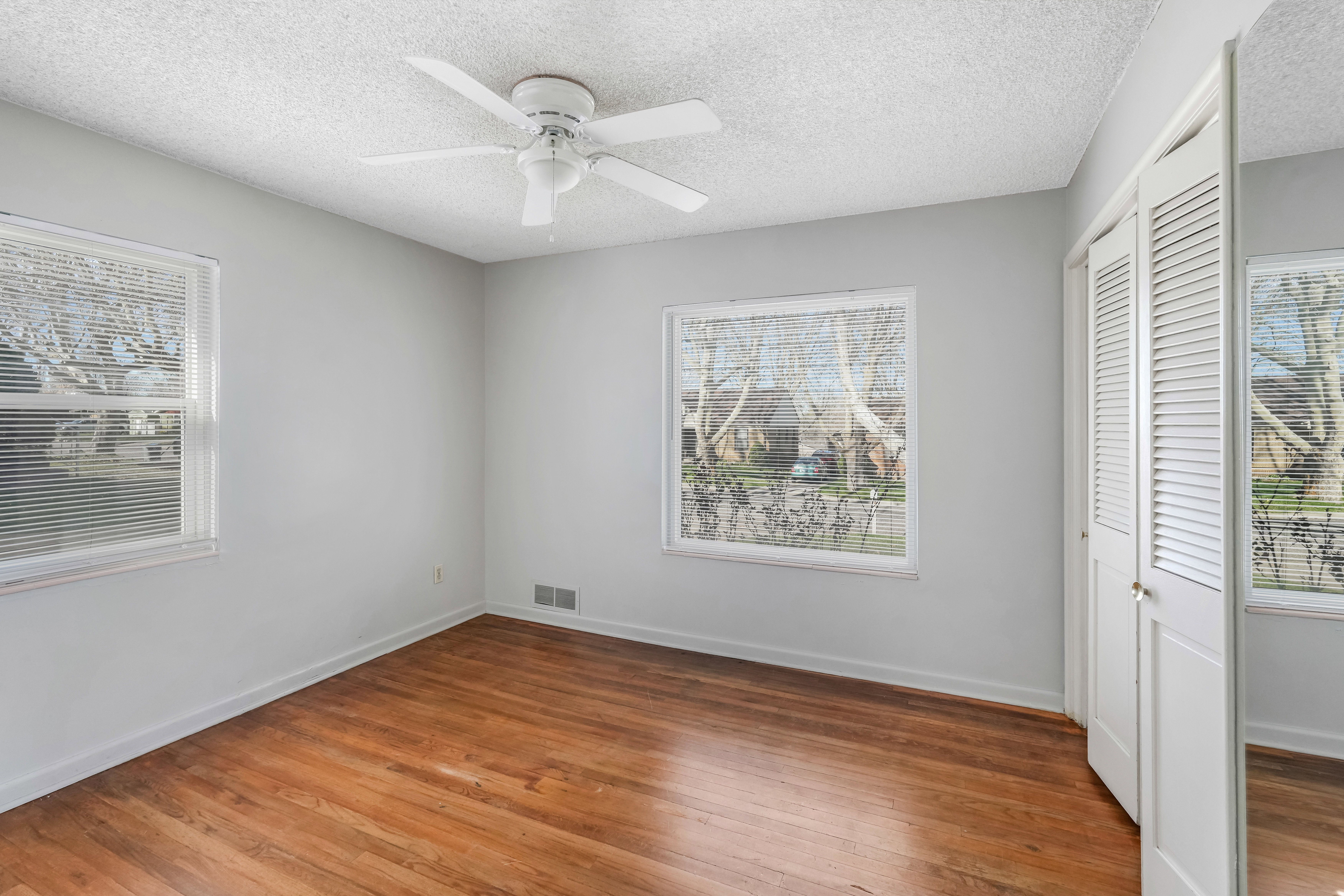 Warm wood-finish flooring complemented by light gray walls