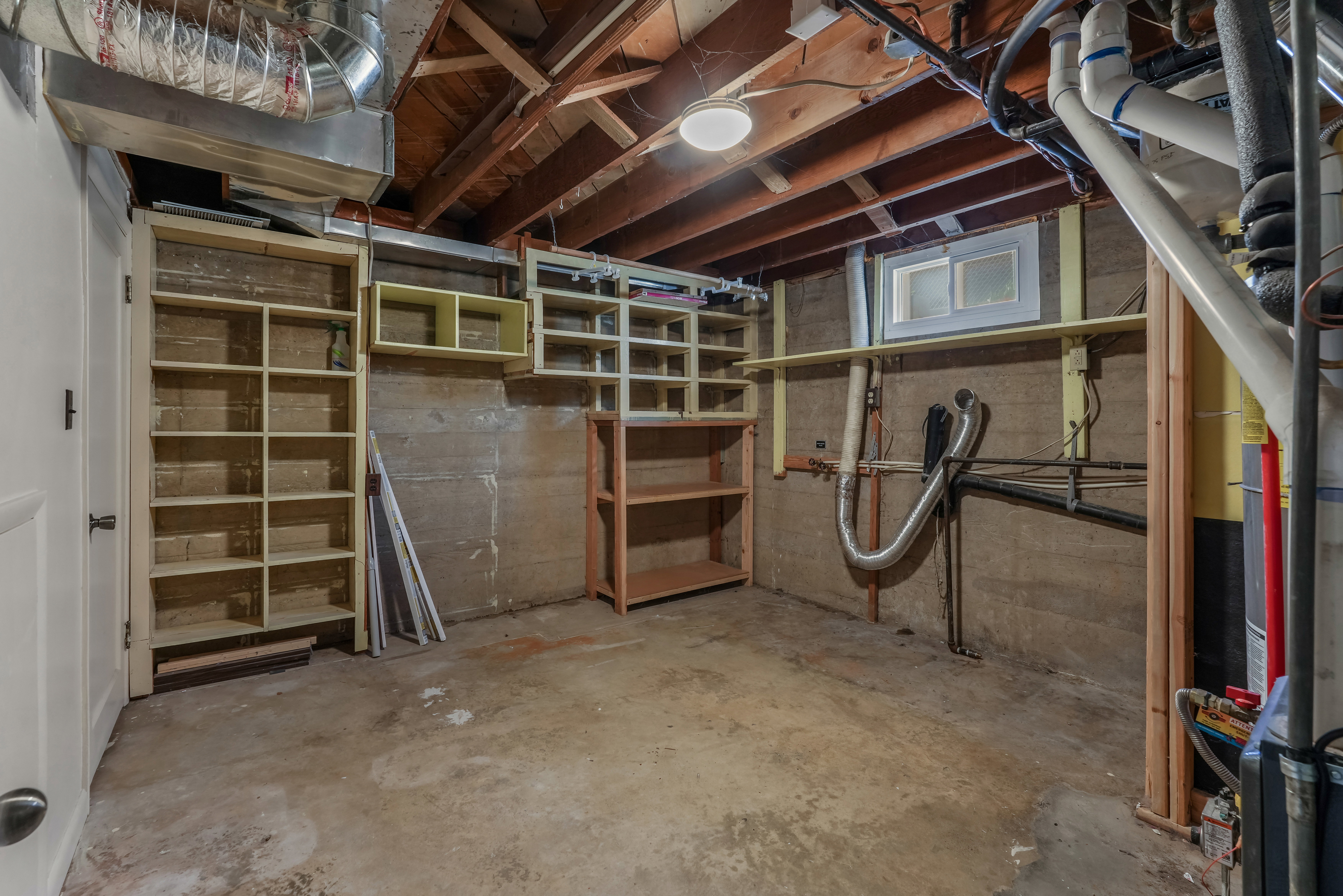 Unfinished basement space featuring exposed wood joists and concrete flooring