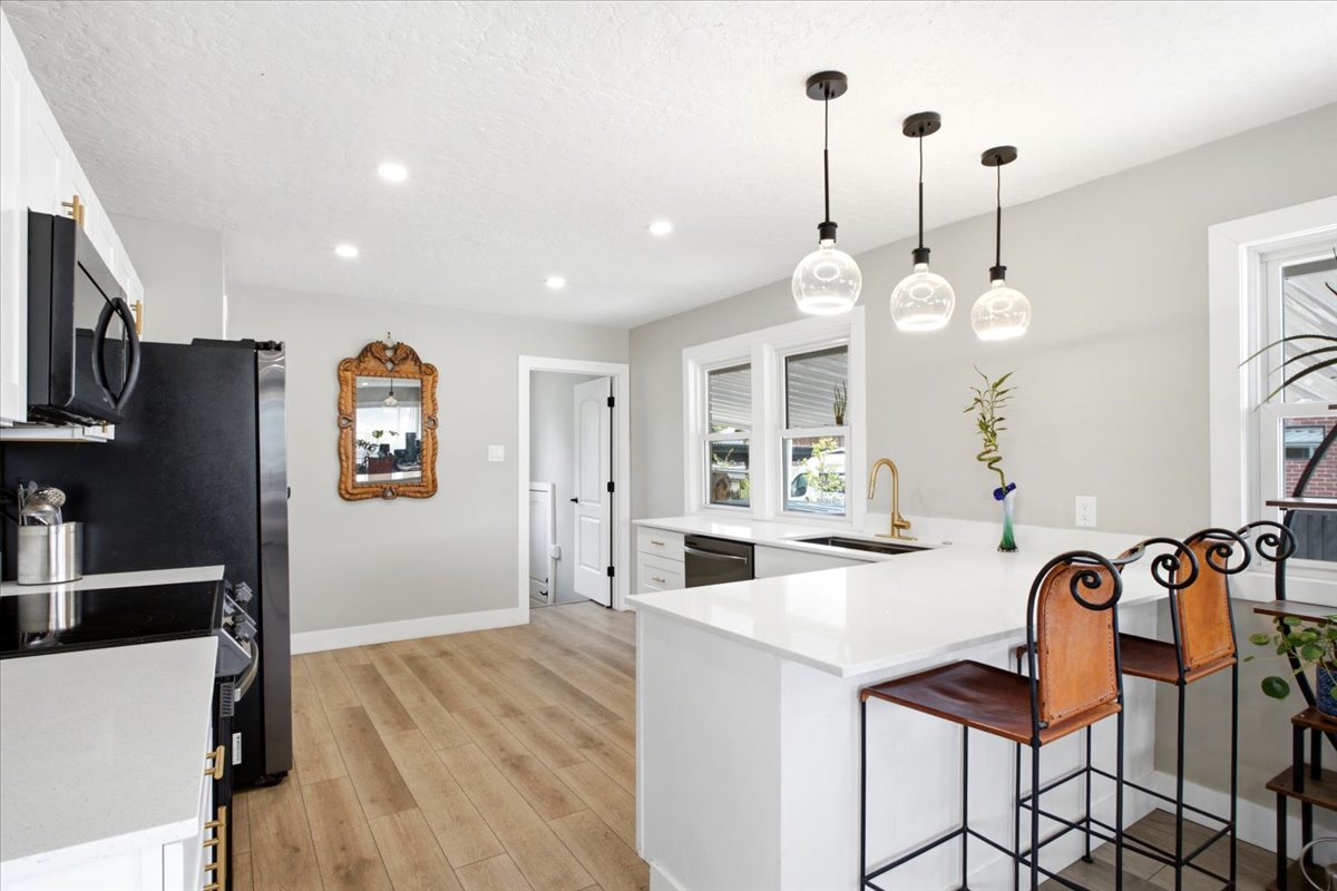 Spacious, updated kitchen features new quartz countertops, large single-basin sink, black stainless steel appliances, abundant cabinetry with brass cabinet hardware, and pantry storage!