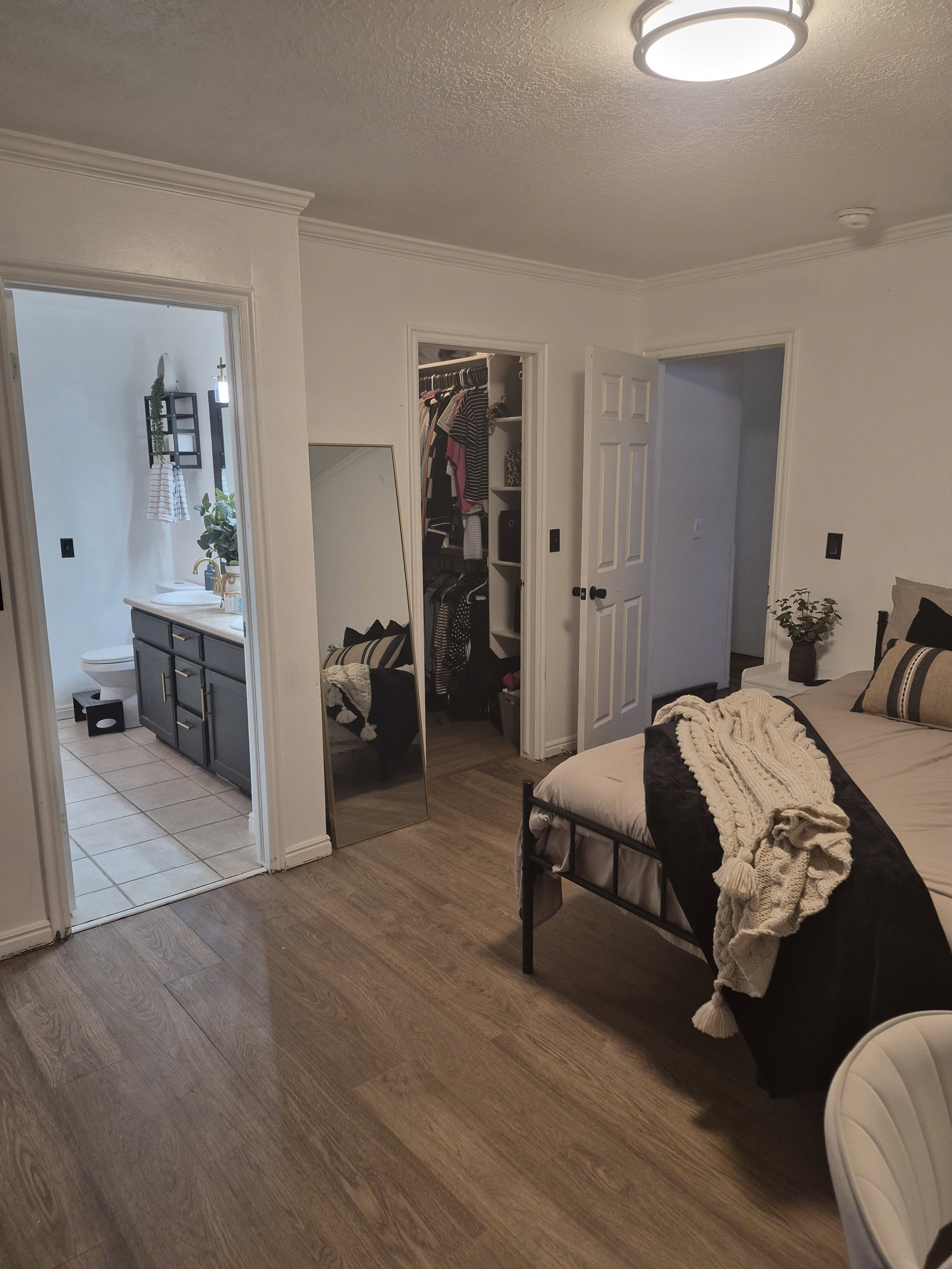 Bedroom featuring wood-finish flooring, crown molding, and a flush-mount ceiling light