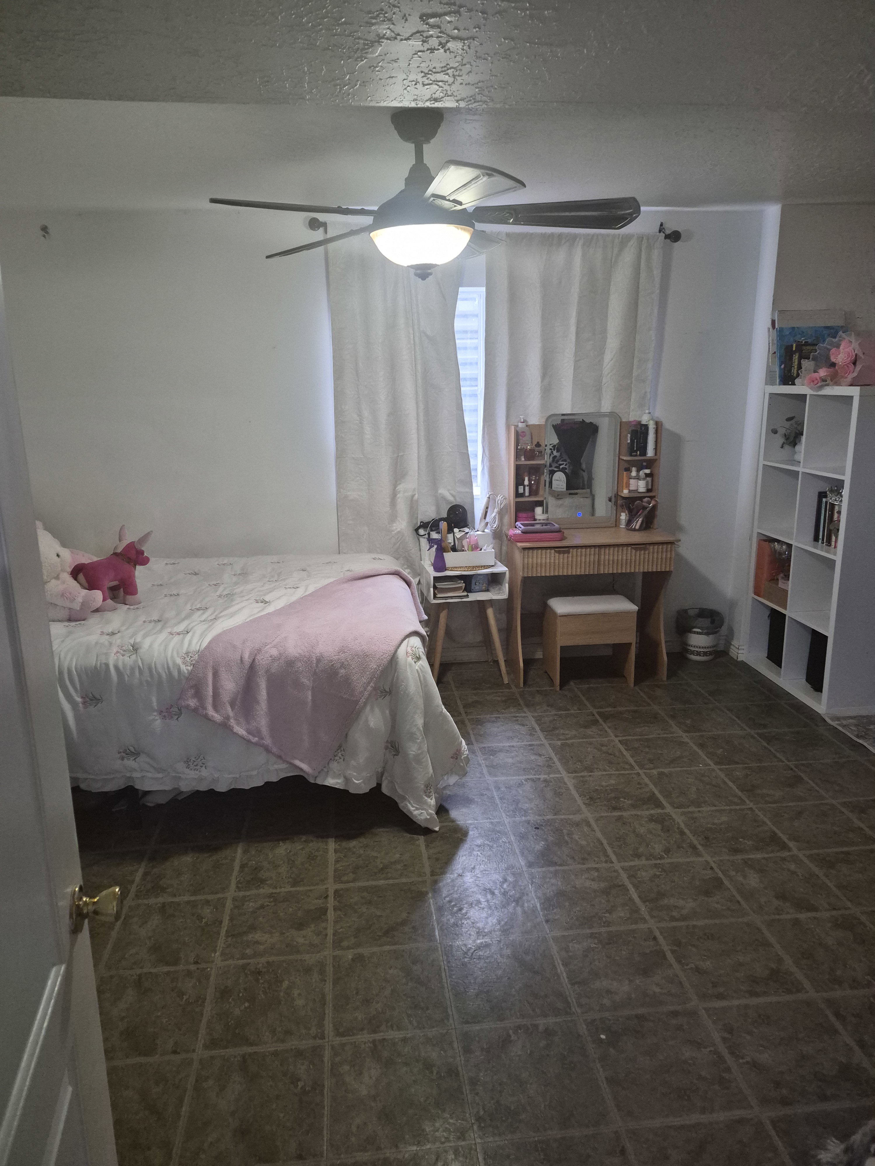 Room with tiled flooring and a ceiling fan with integrated lighting