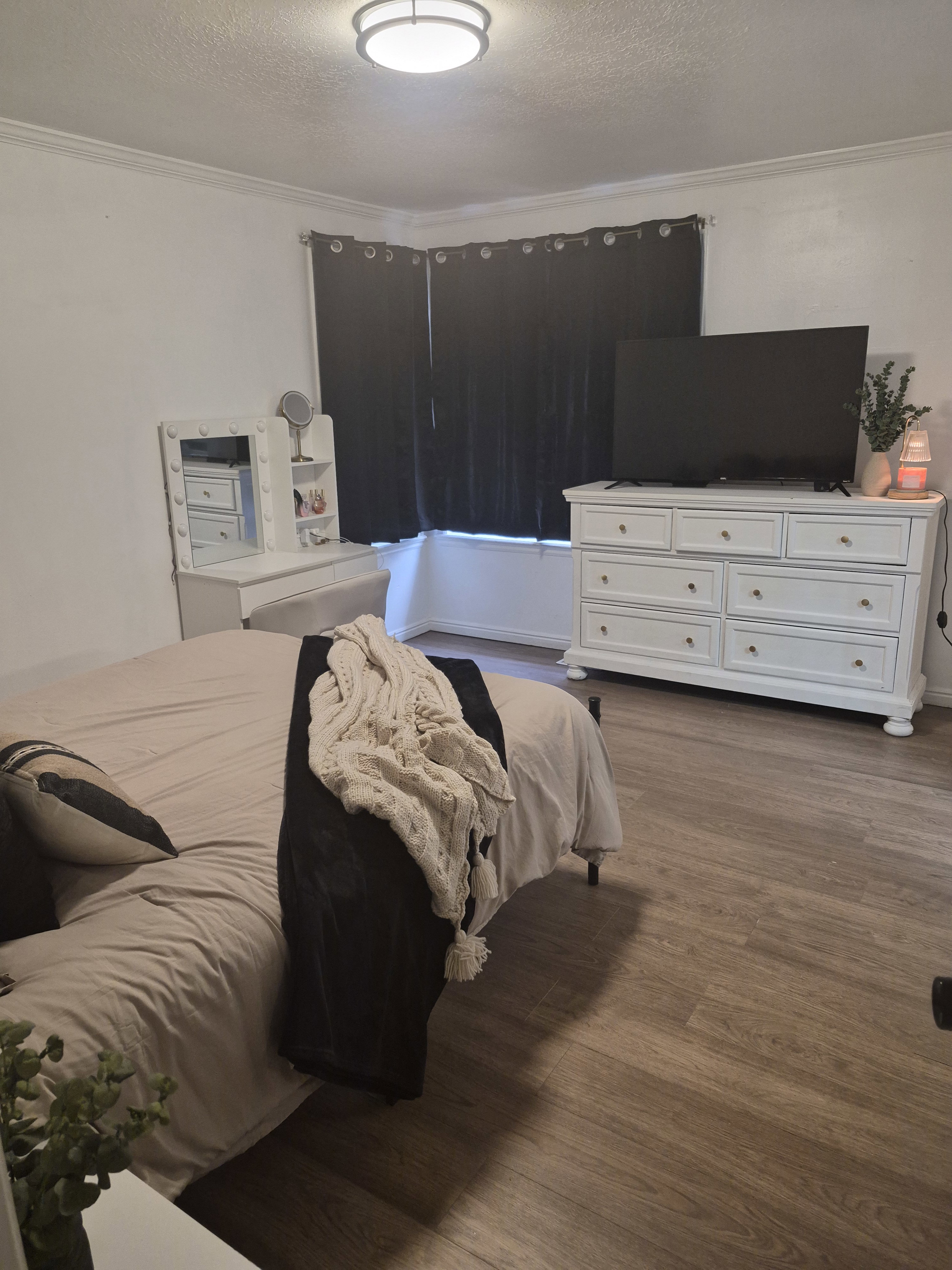 Interior room featuring wood-finish flooring, white crown molding, and a flush-mount ceiling light