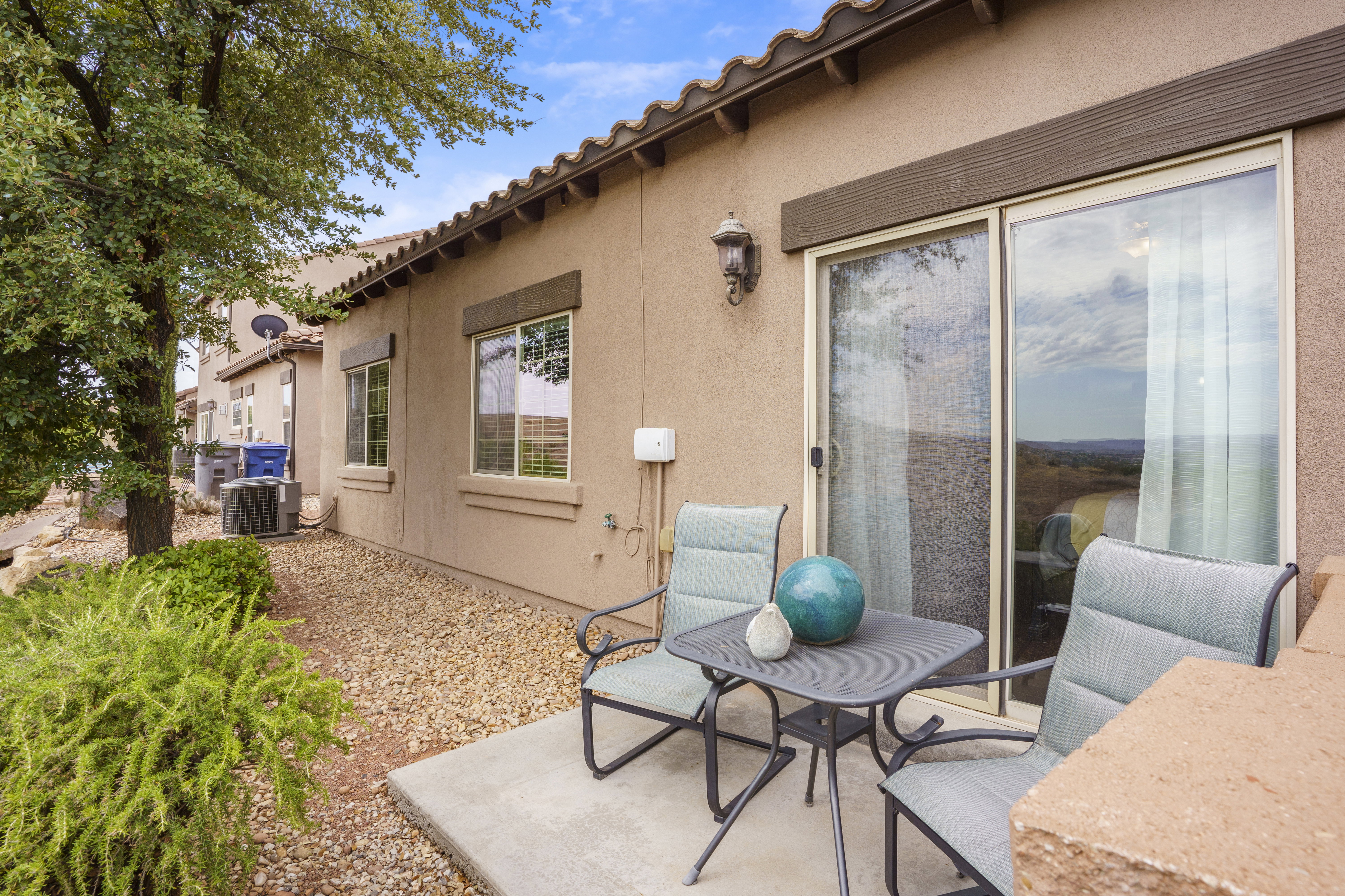 Patio area featuring a stucco exterior, concrete paving, and a sliding glass door