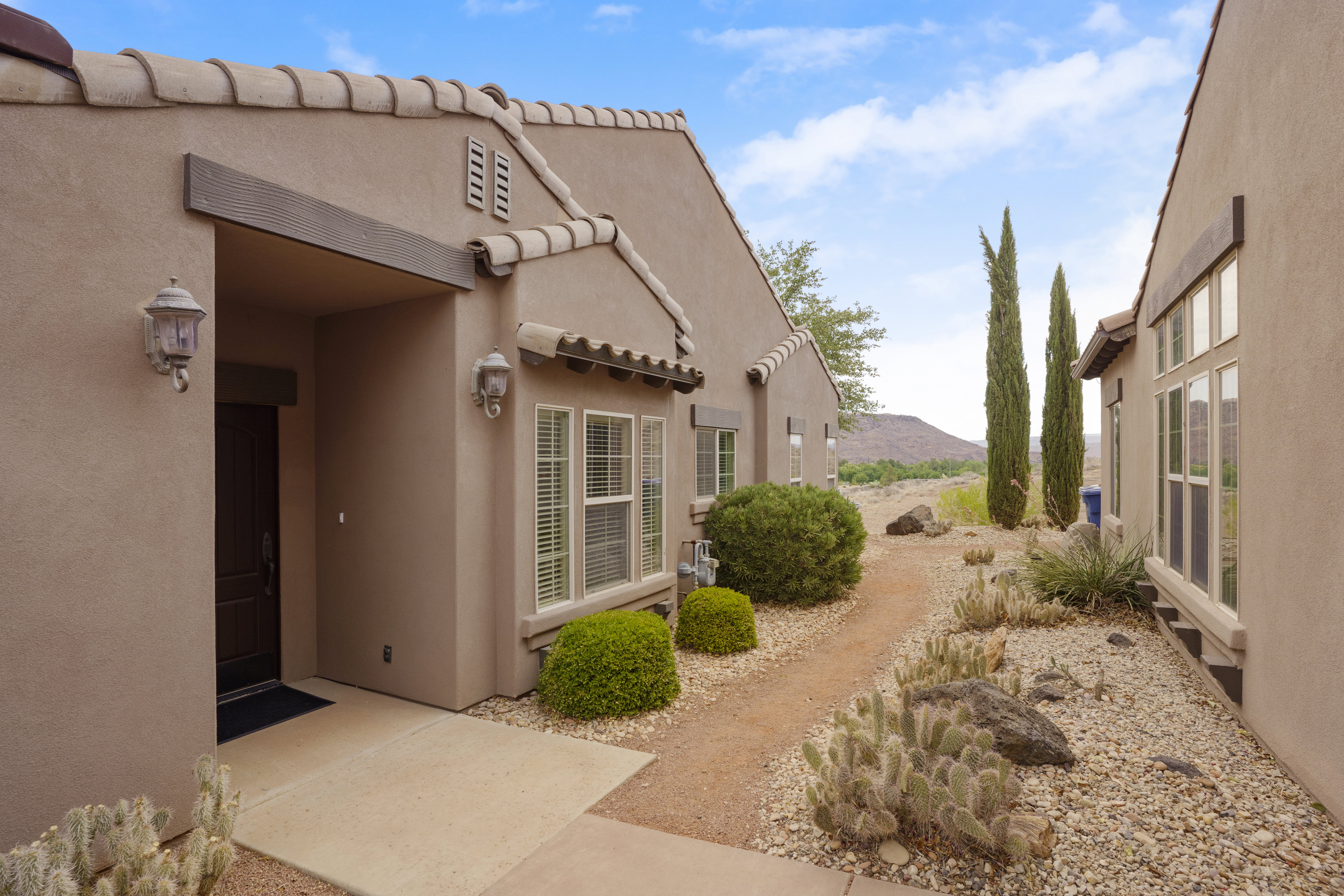 Southwestern-style exterior featuring a tile roof, stucco finish, and an inviting entry with dual sconces
