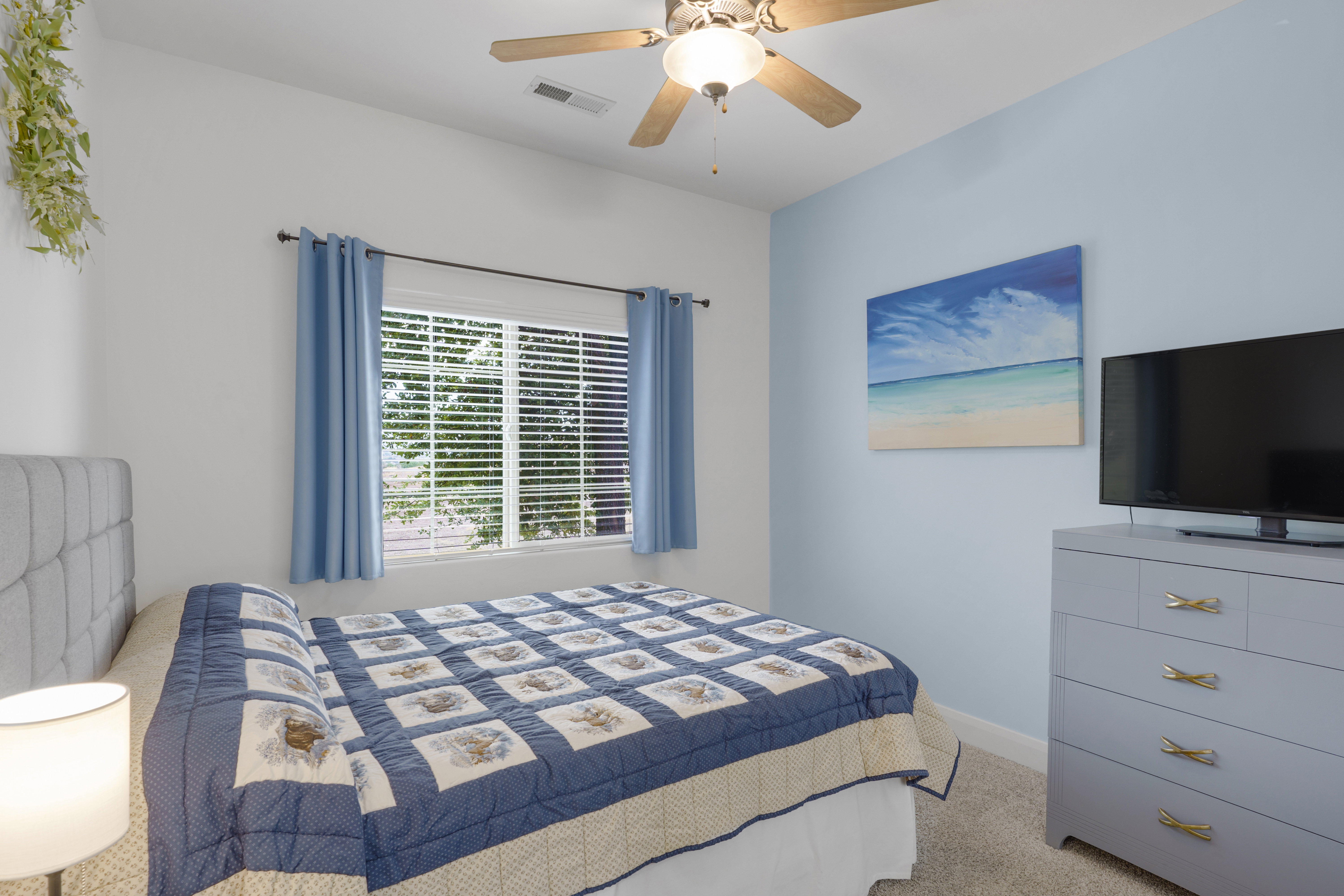 Bedroom featuring a window with blinds, ceiling fan with light fixture, carpeted flooring, and a light blue accent wall