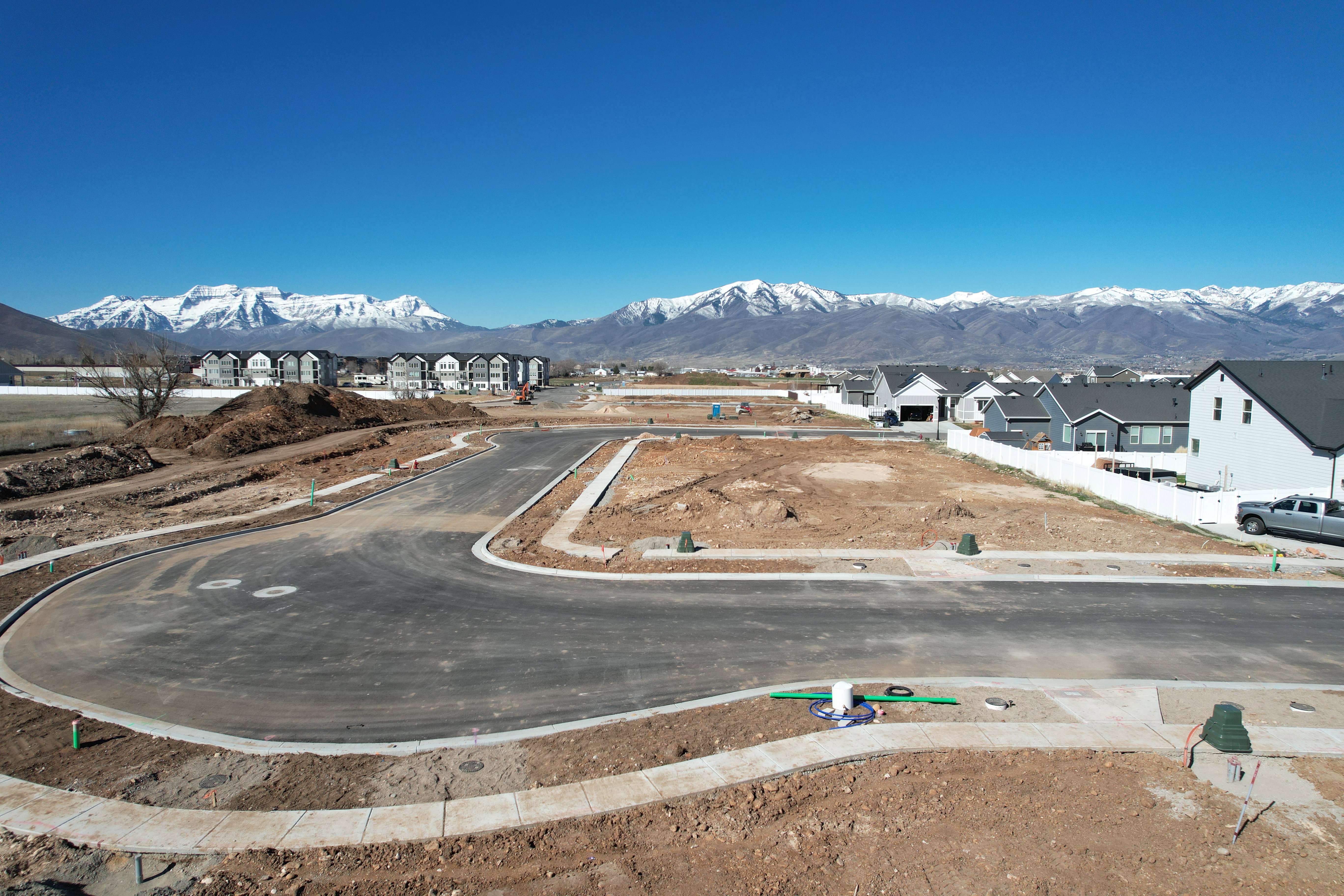 Mountain backdrop, newly paved streets, established curbs, and visible utilities