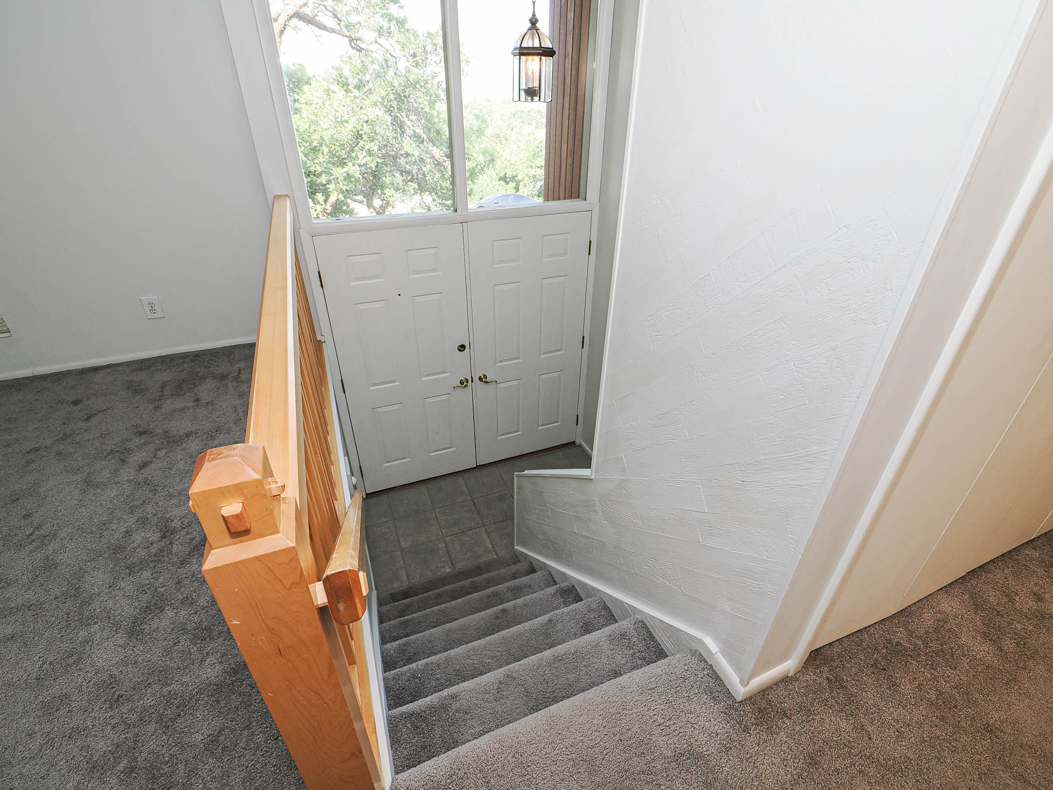 Foyer with a double-door entry, tile flooring, and an overhead pendant light fixture