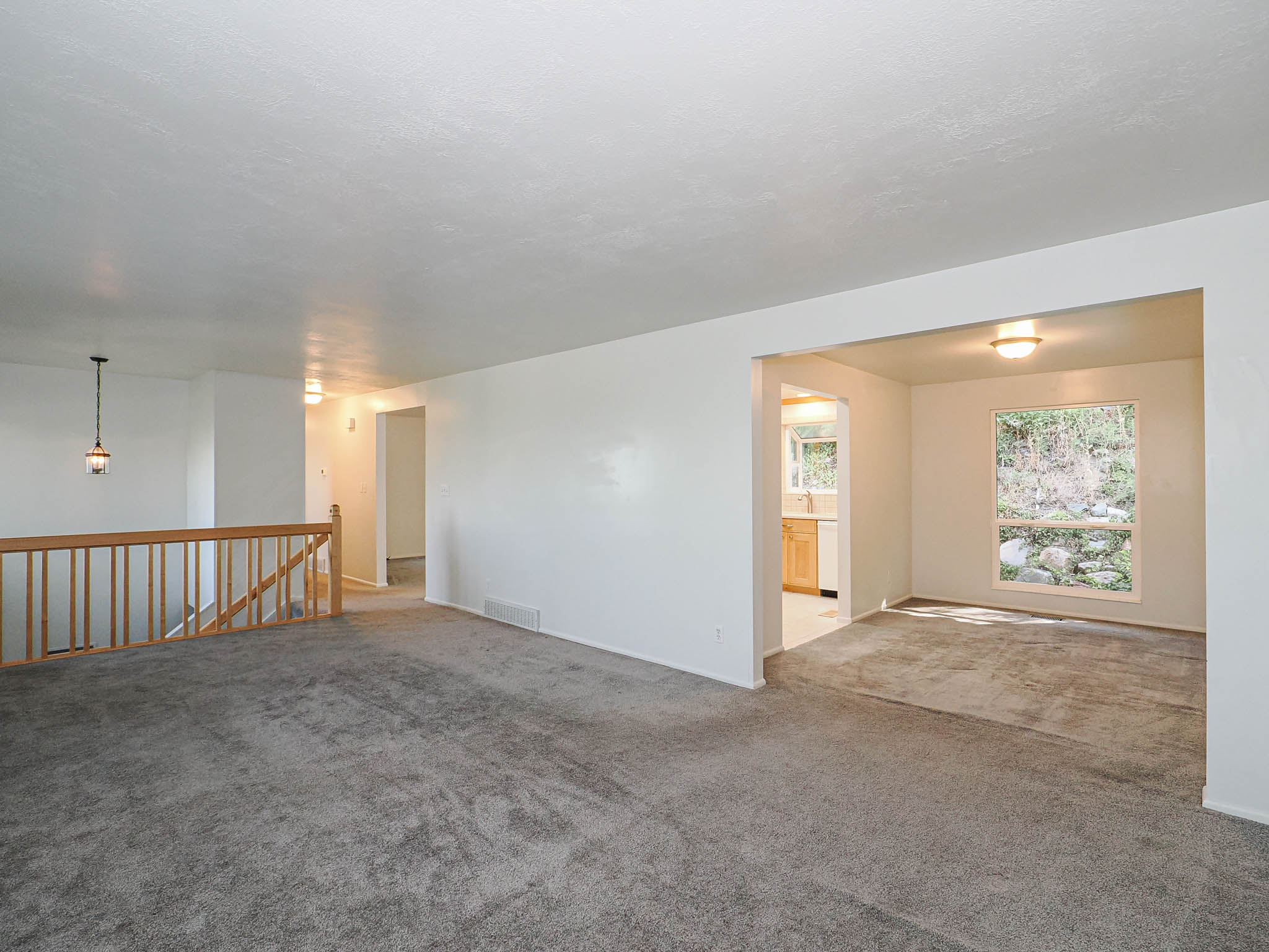 Spacious living area featuring neutral carpeting and light-toned walls