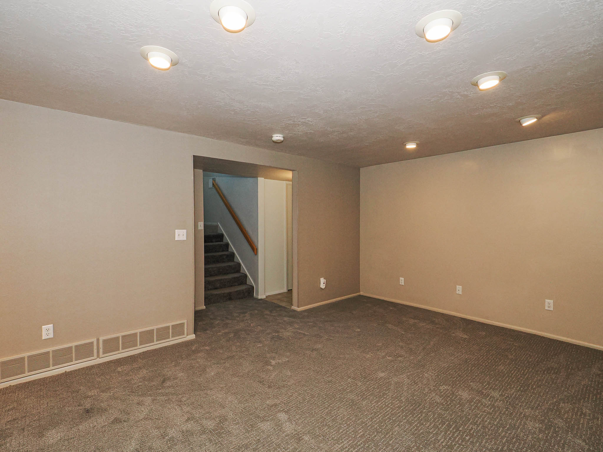 Spacious room featuring neutral carpeting and recessed lighting