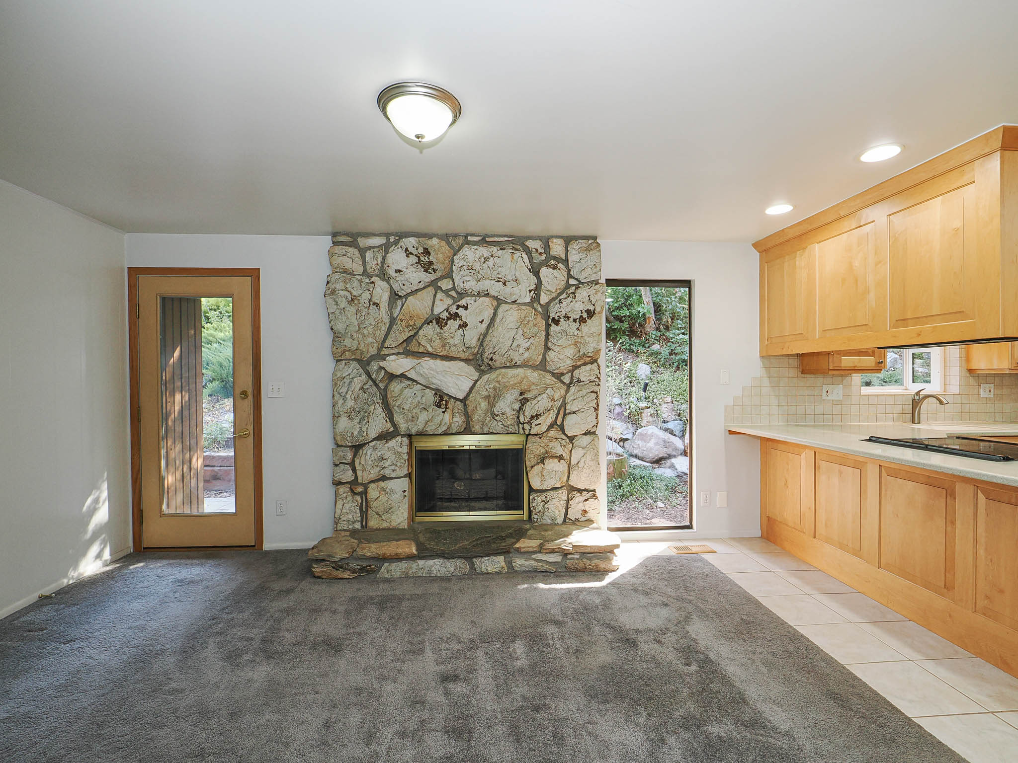 Expansive stone fireplace with a raised hearth, complemented by a stone accent wall