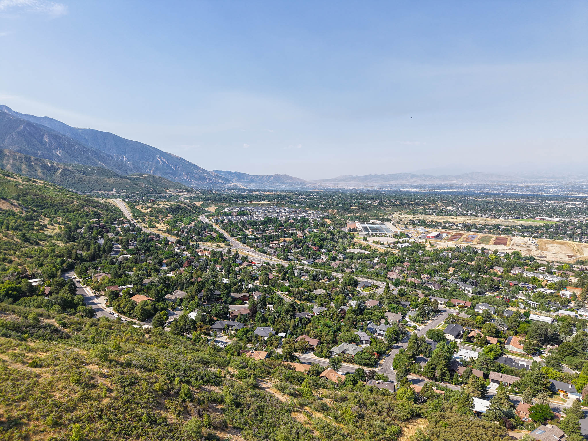 Expansive aerial panorama showcasing a suburban development nestled against a mountain range