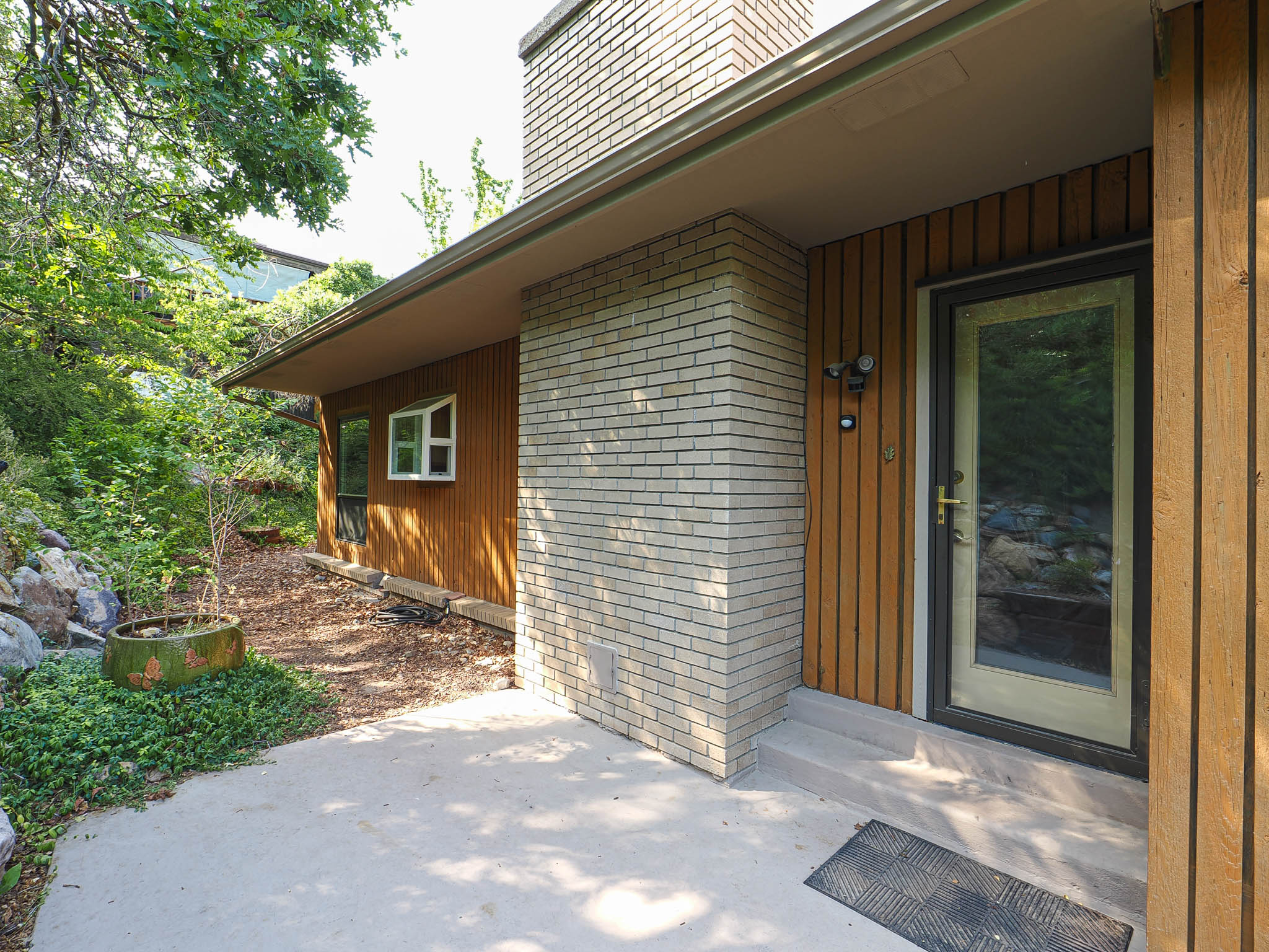 Exterior entry featuring light brick and vertical wood siding