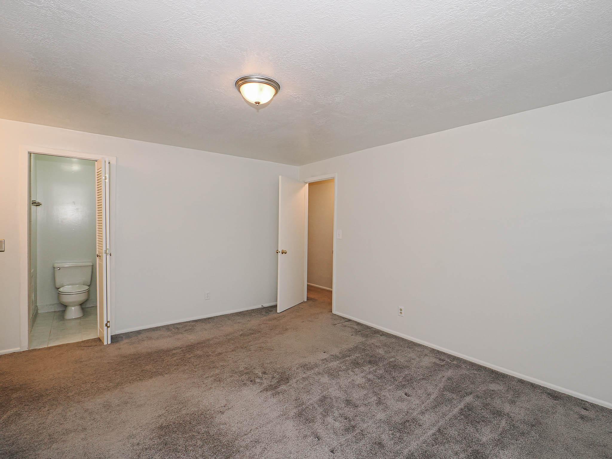 Spacious room featuring neutral carpeting and white walls