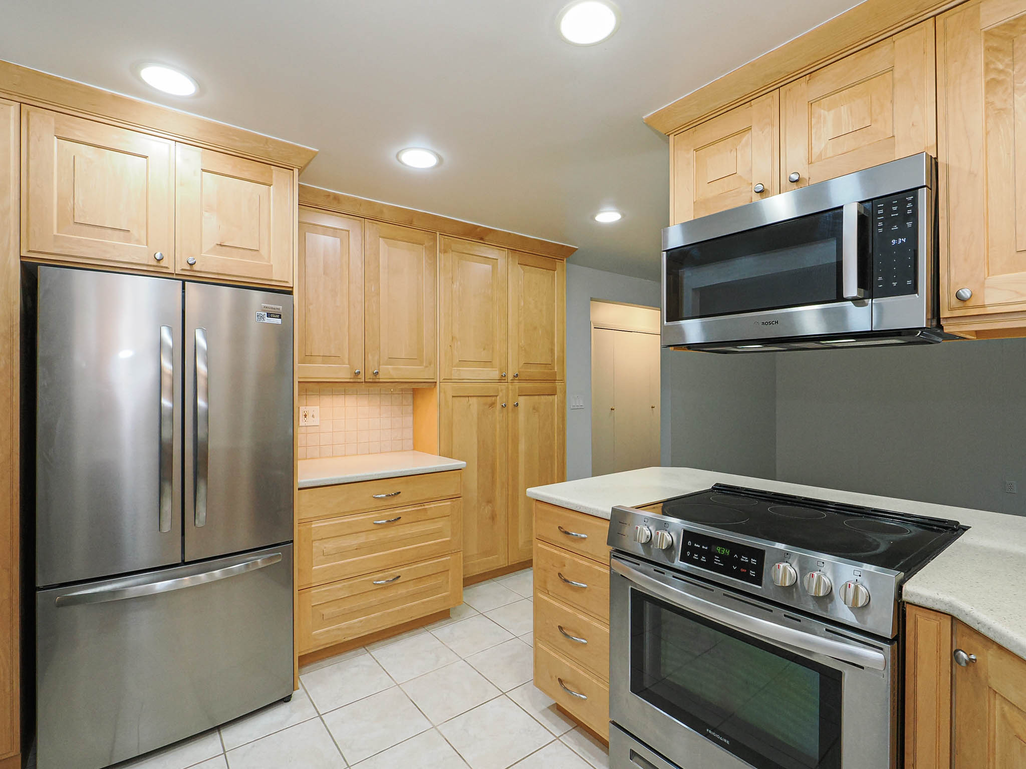Kitchen featuring wood cabinetry, stainless steel appliances, and recessed lighting