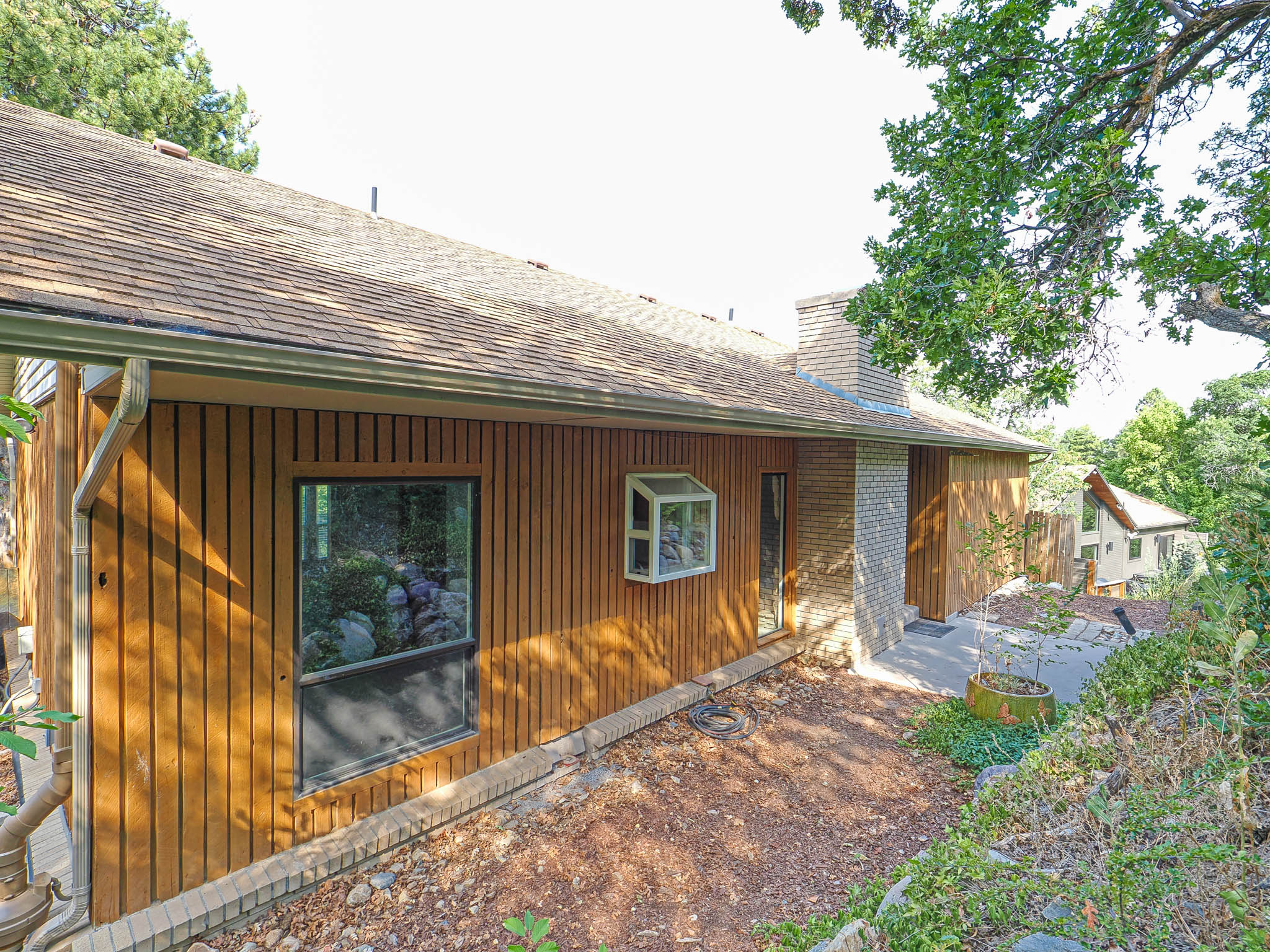 Wood-panel exterior featuring a shaker shingle roof and a brick chimney
