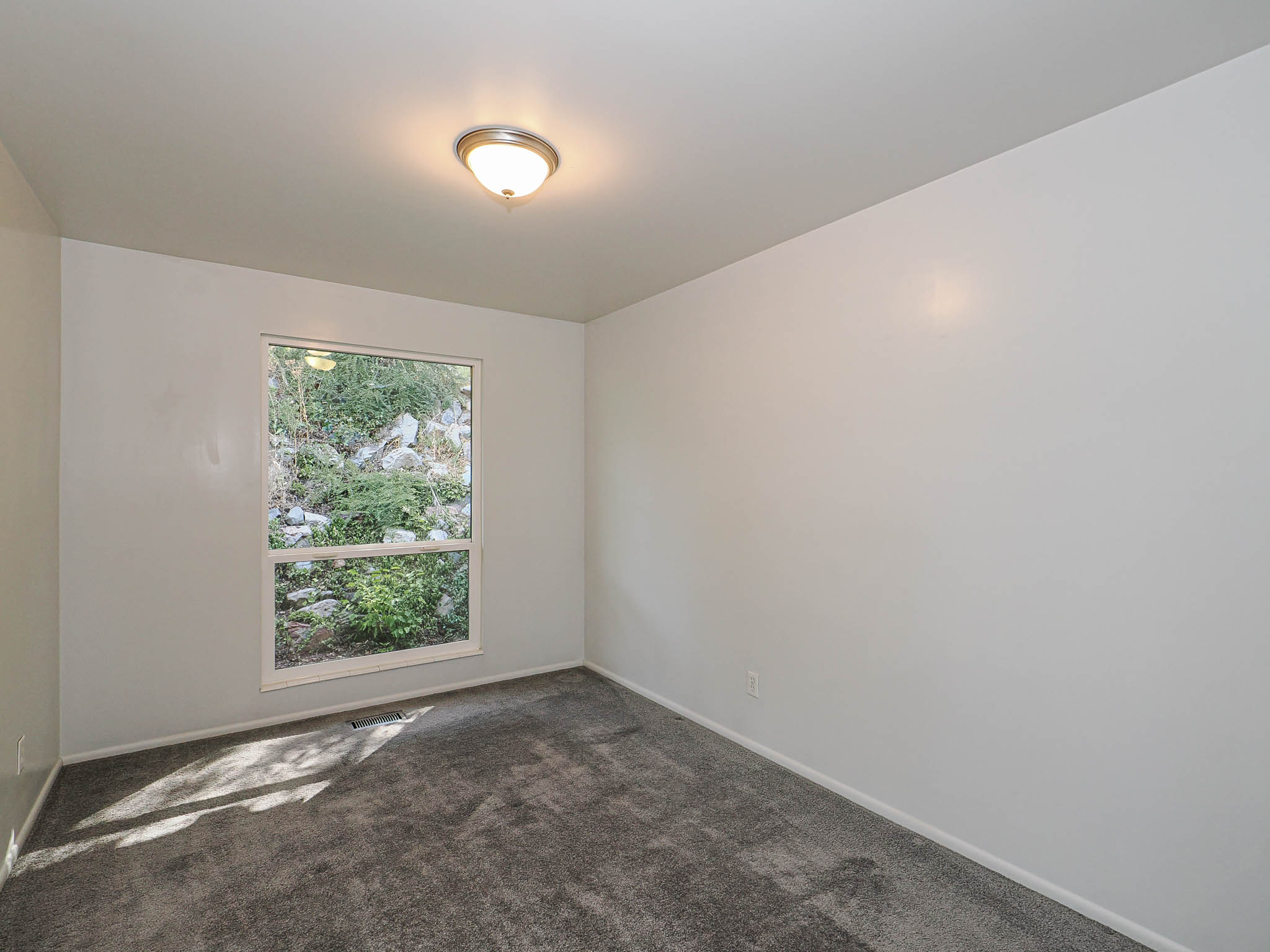 Room featuring a large window, neutral wall finishes, and gray carpeting